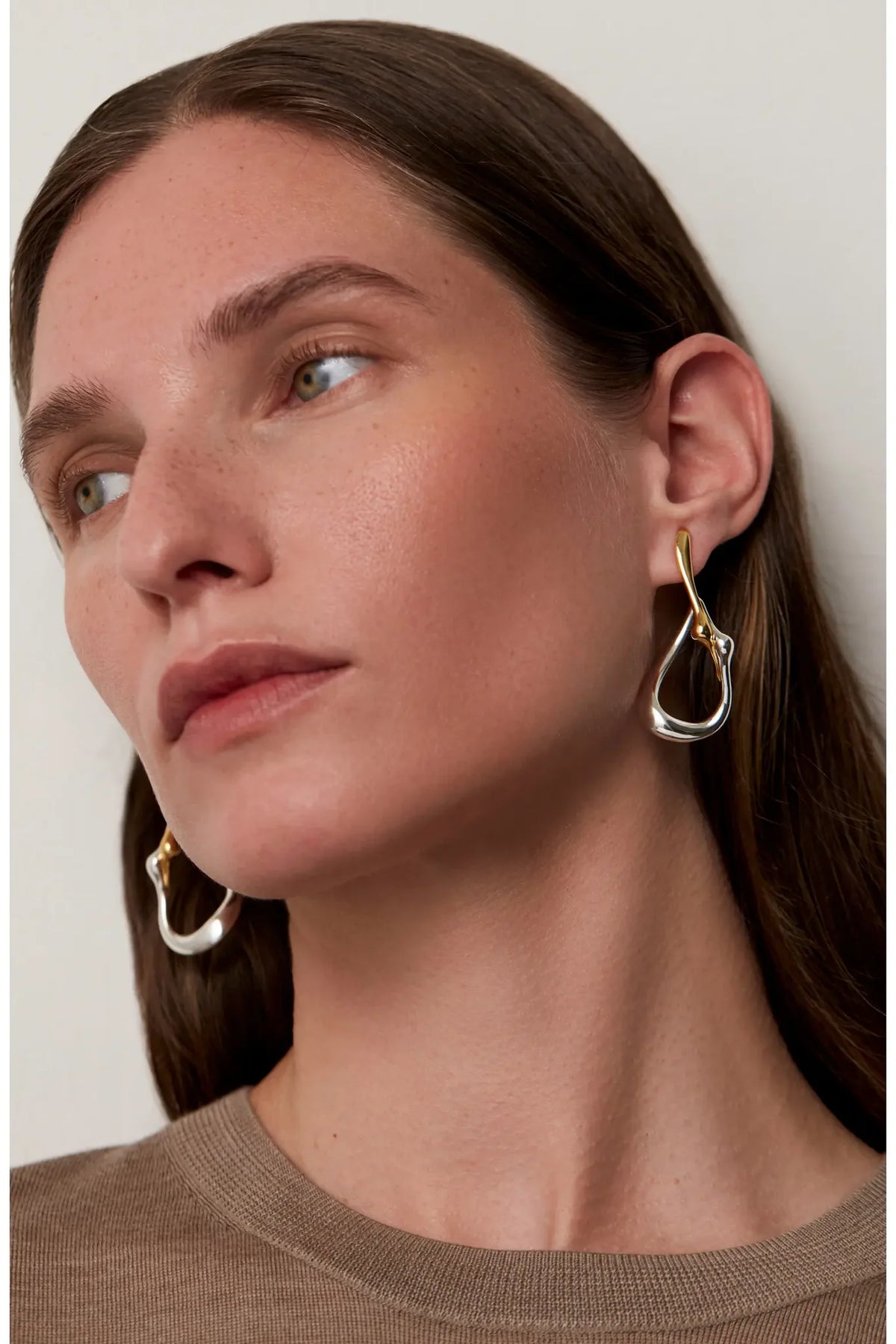 Jenny Bird Egret Hoops two-tone gold and silver abstract sculptural earrings on model