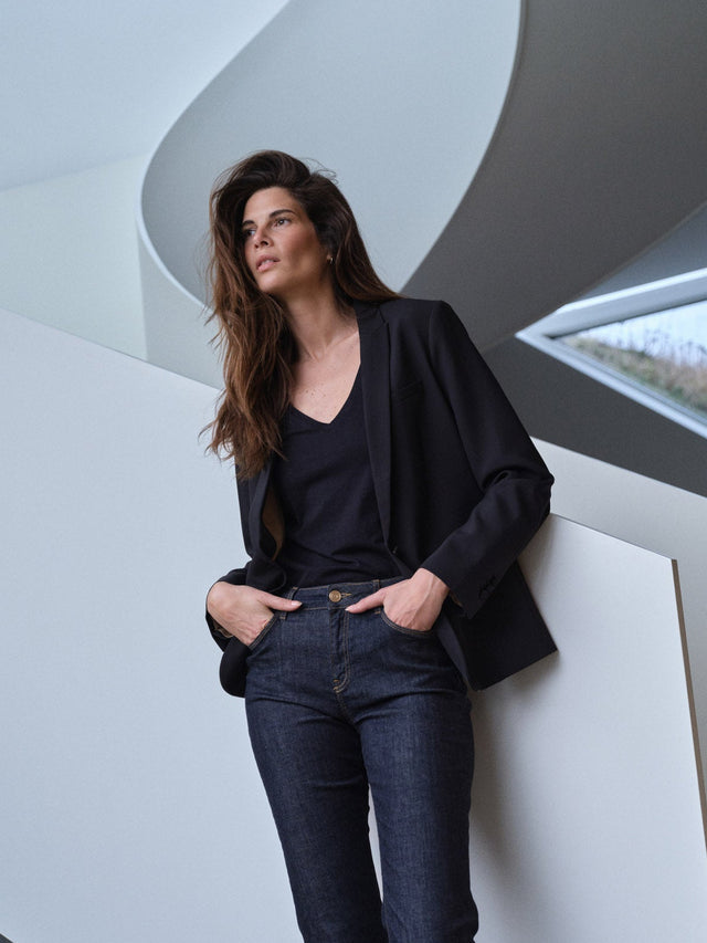 Black oversized blazer worn open over dark jeans and black v-neck top
