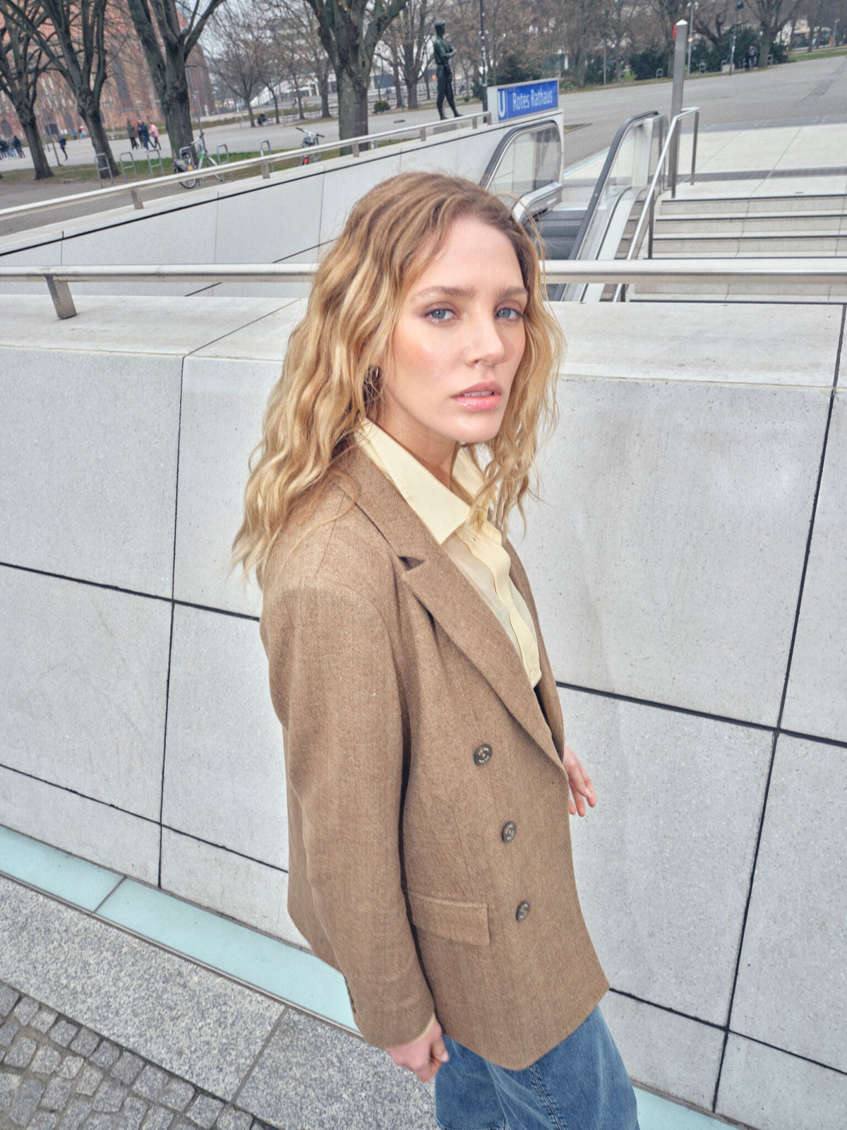 Model wearing Mos Mosh Bethie Case Blazer in dark camel double-breasted style outdoors