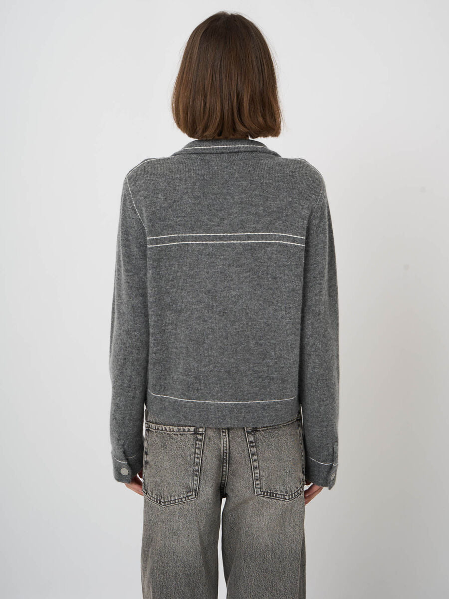 Grey wool cashmere cardigan with white contrast stitching, back view, paired with grey jeans