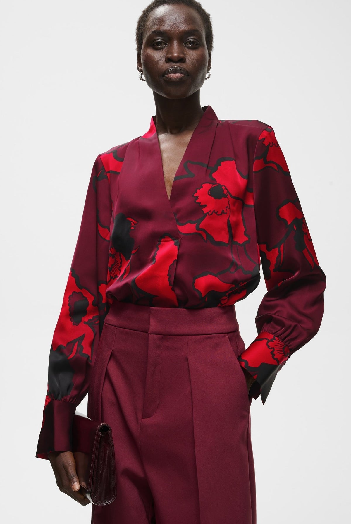 Burgundy satin V-neck blouse with bold red and black floral print, long sleeves