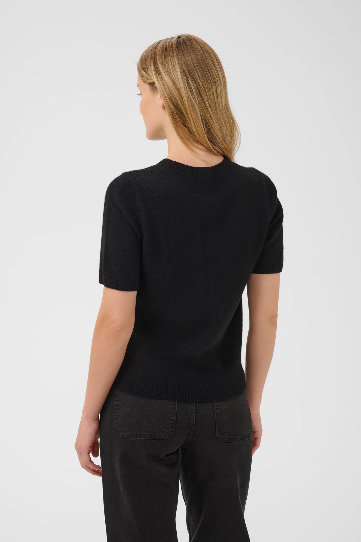 Black short-sleeve knit sweater, crew neck, ribbed hem, back view on model