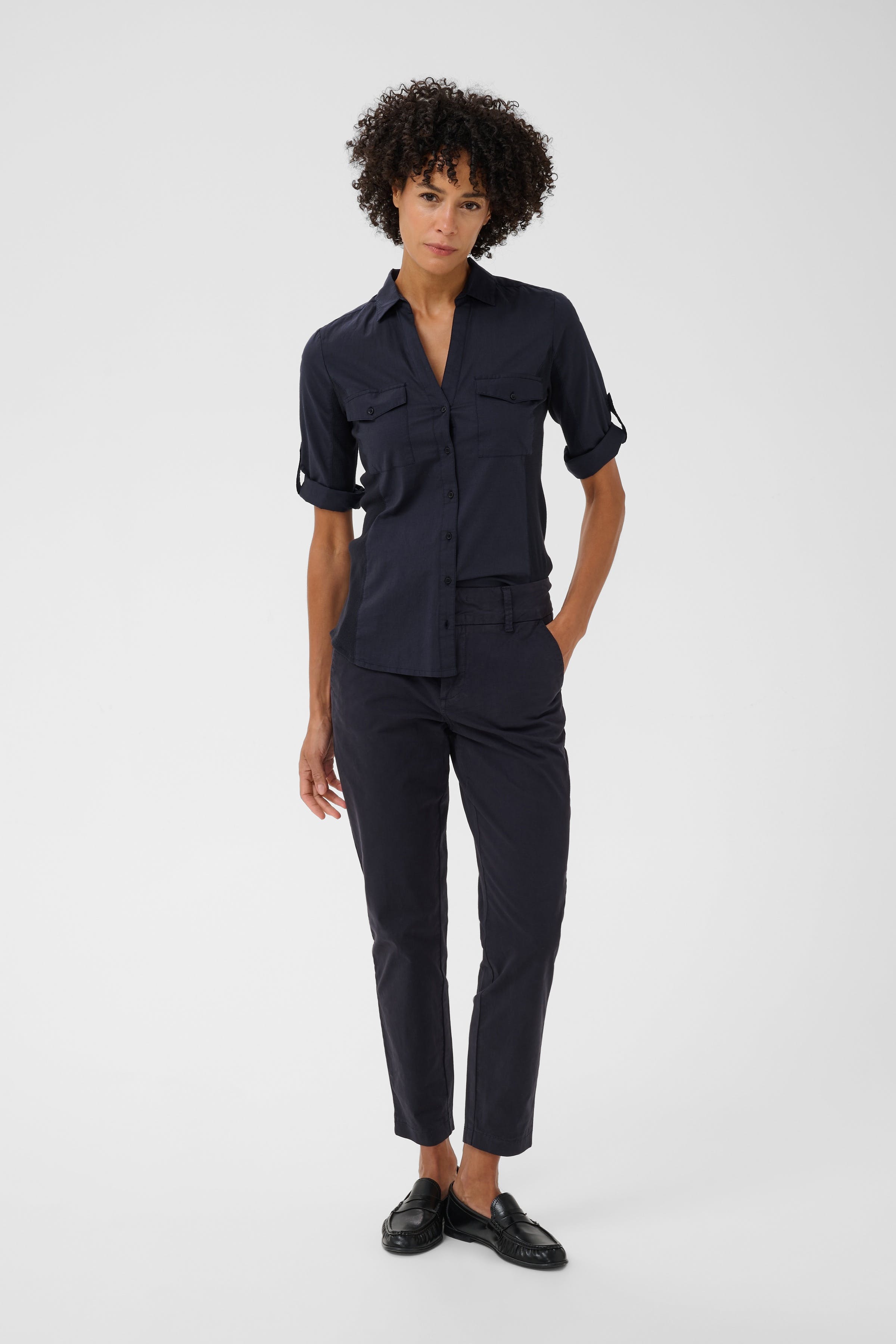 Model wearing Part Two Netta Pants in dark navy with matching navy shirt and black loafers.