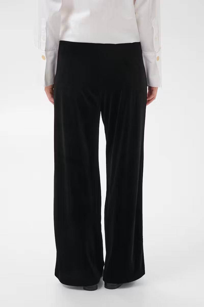 Part Two Dhanyo wide-leg black velvet trousers, back view, paired with white shirt