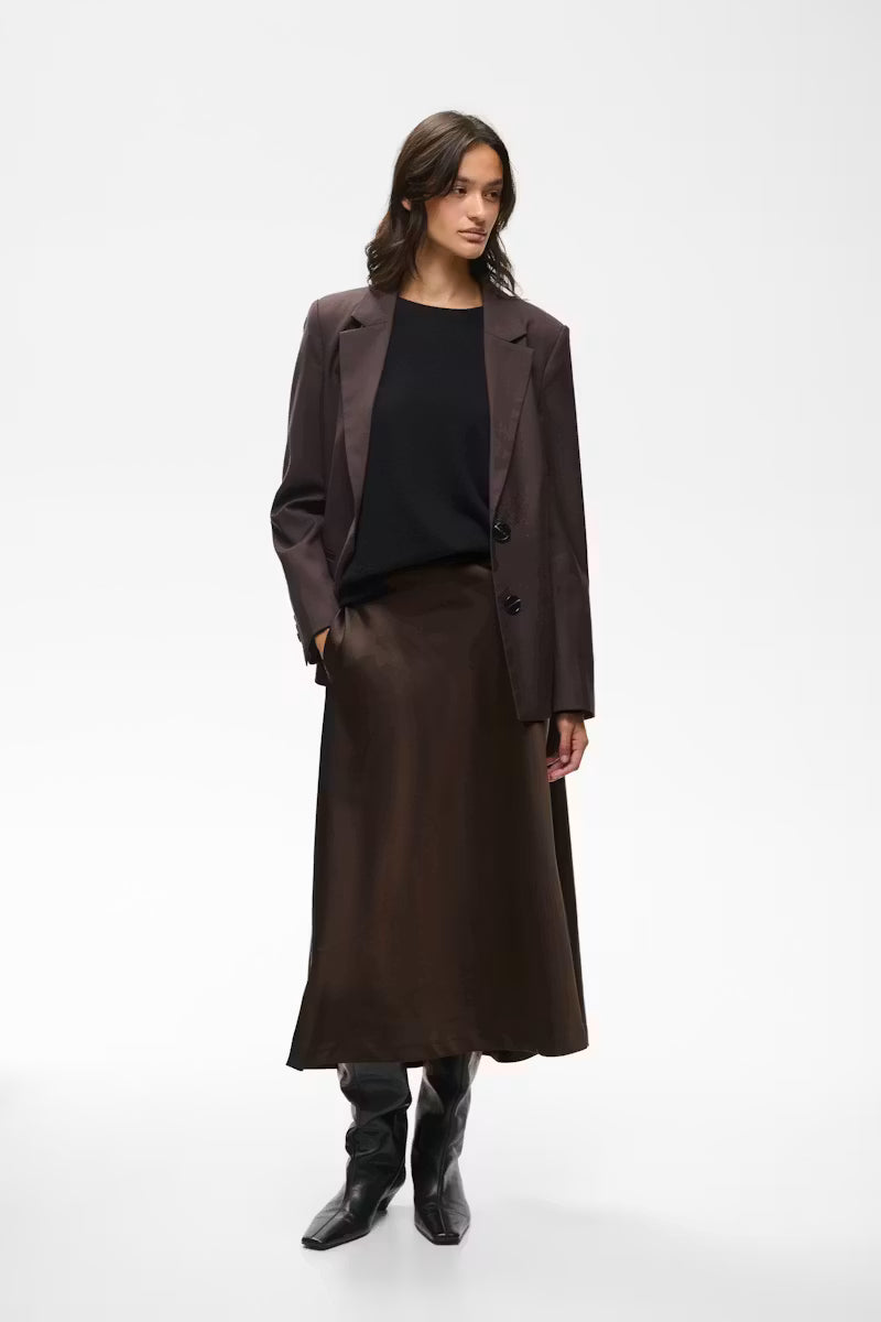 Chocolate brown satin midi slip skirt with smooth flared hem, styled with blazer