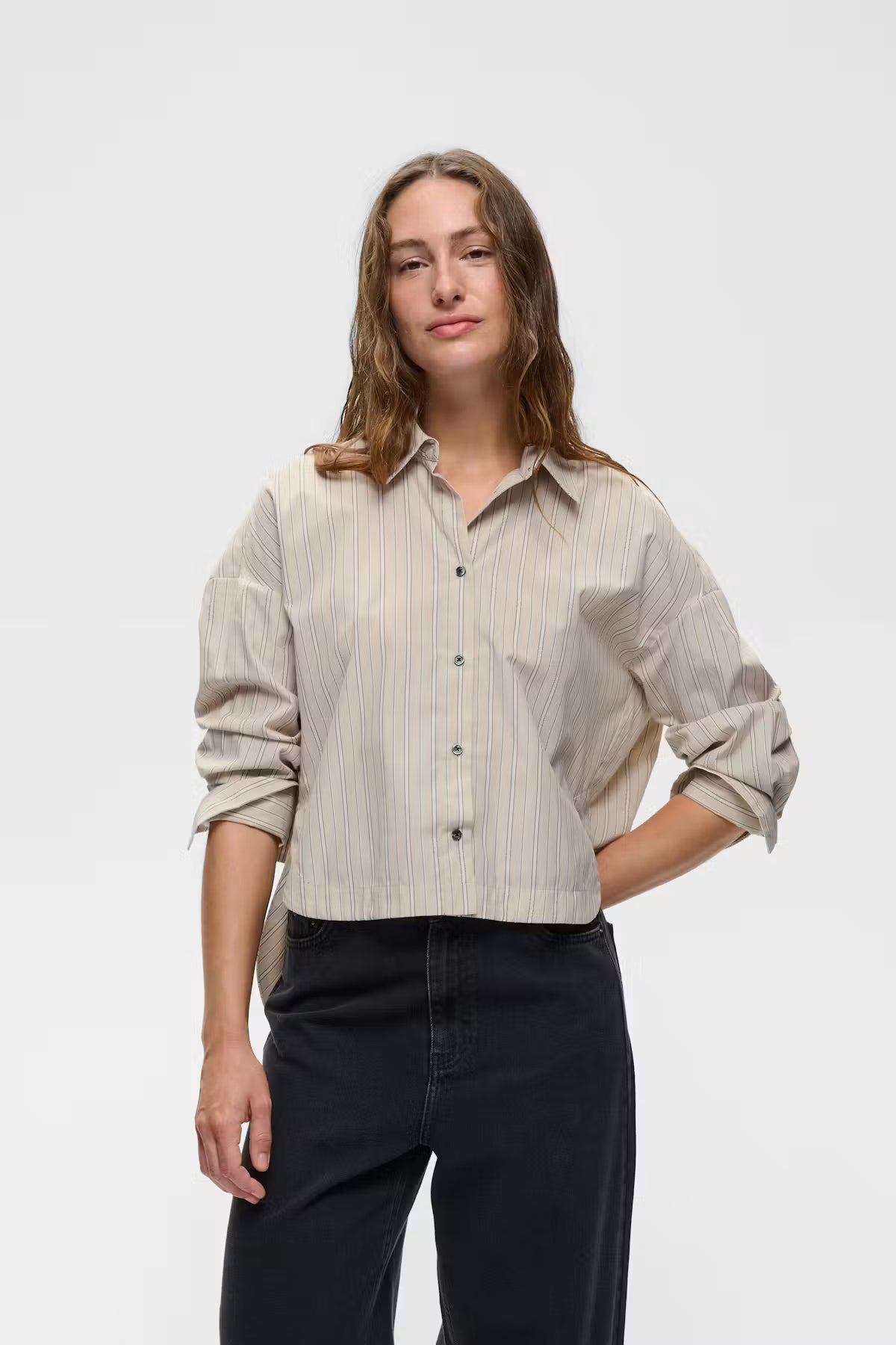 Cropped beige pinstripe button-up shirt with long sleeves and classic collar