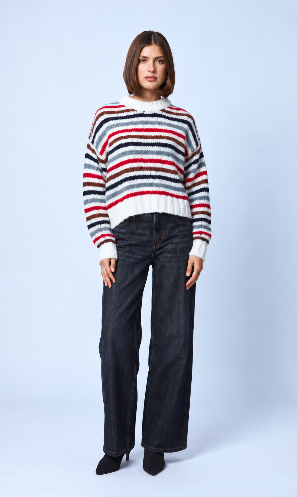 Model wearing Line the Label Theodora striped knit sweater in Tundra Stripe with wide-leg dark jeans