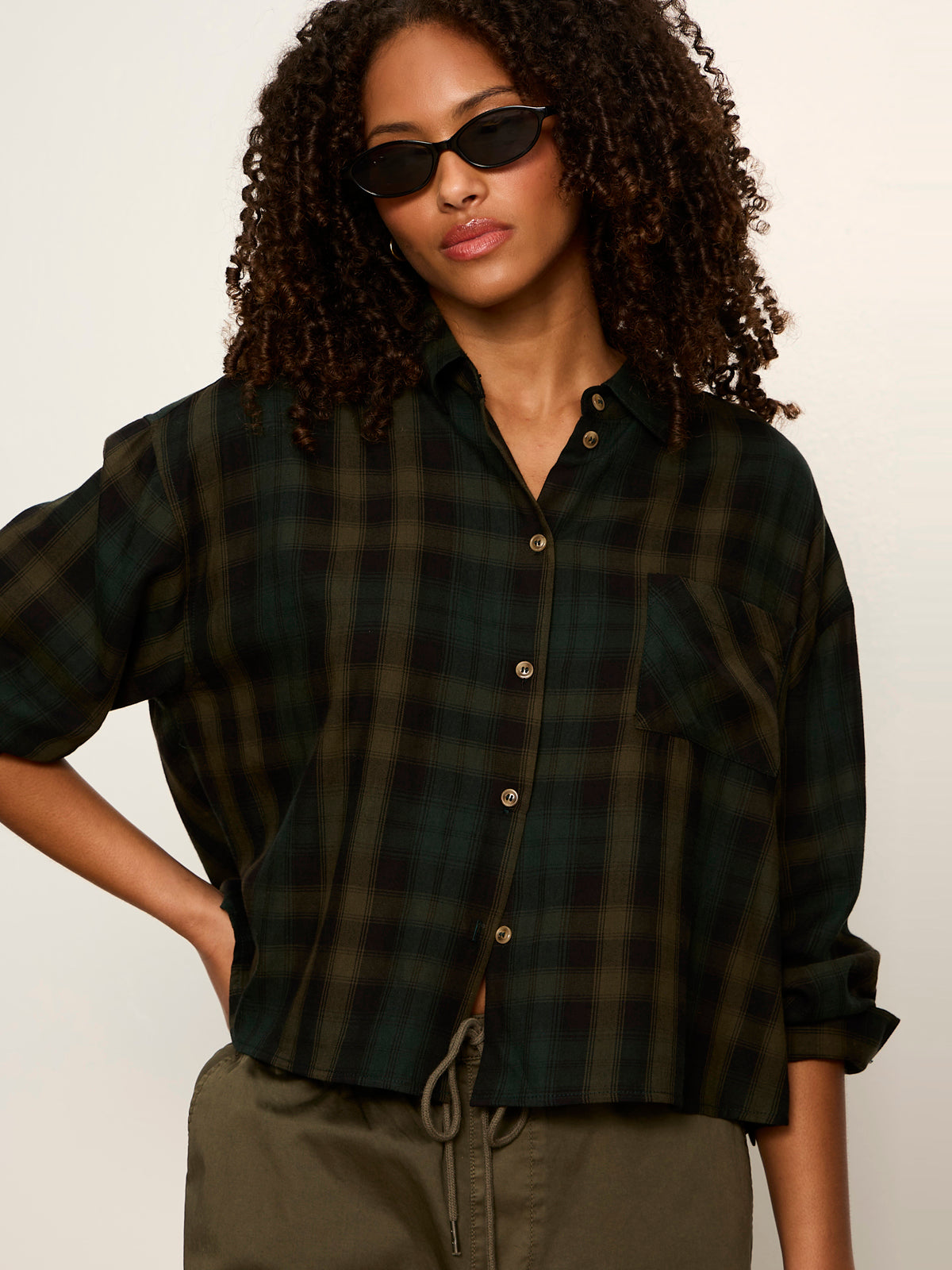 Model wearing Sanctuary Autumn Edit Flannel cropped shirt in dark forest green plaid pattern
