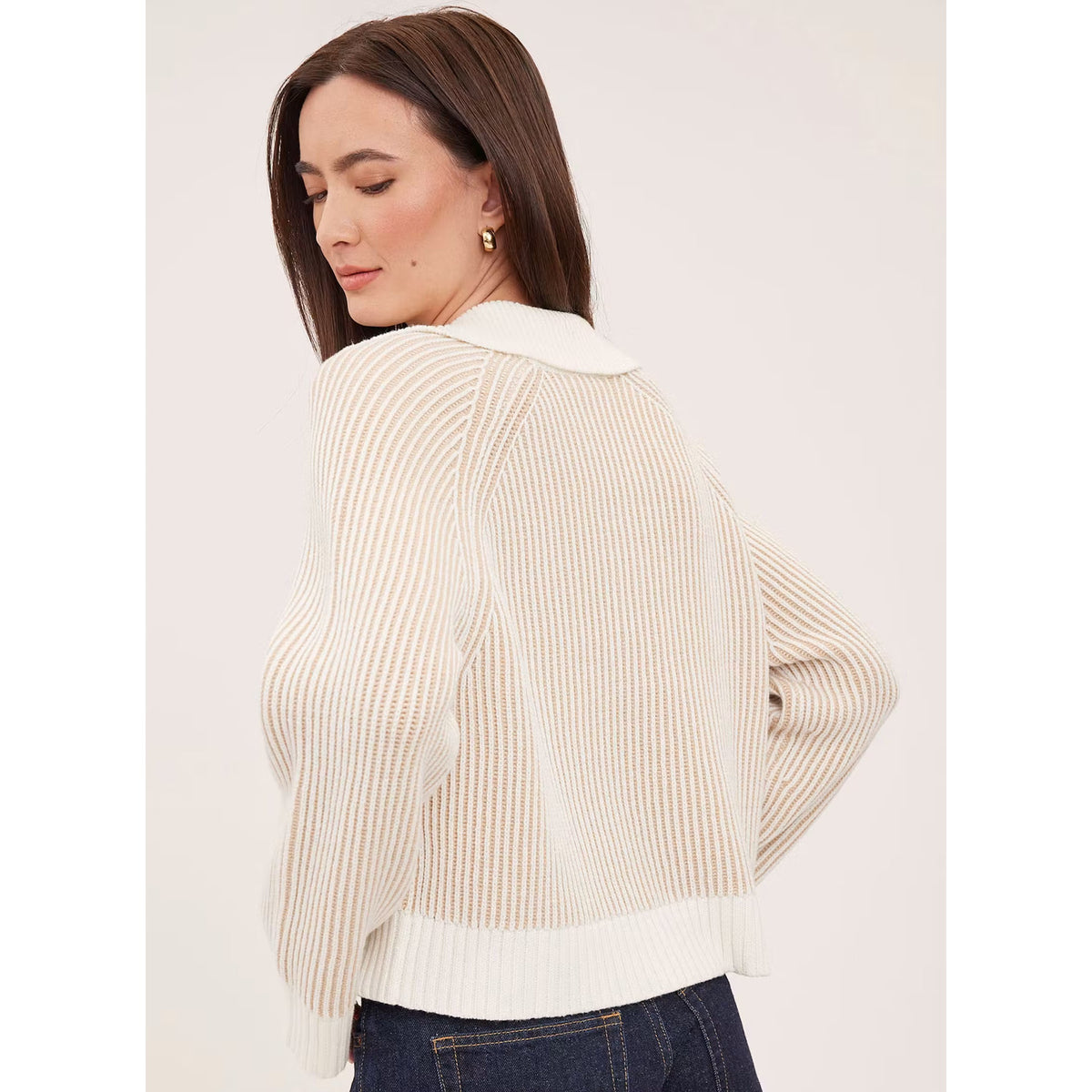 Back view of woman wearing cream ribbed knit sweater with collar and long sleeves