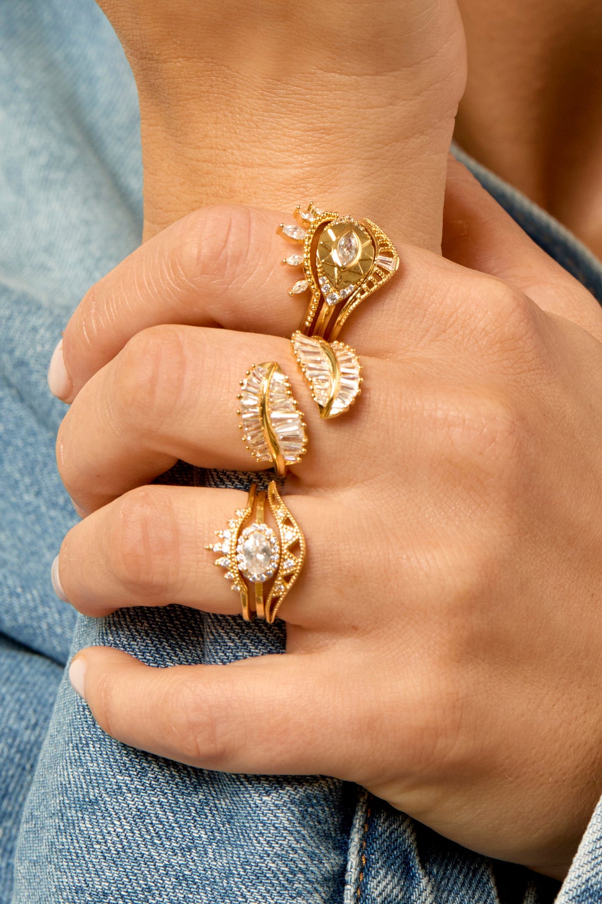 Gold crystal-embellished evil eye rings stacked on model's fingers, MYA-BAY ASTRA collection