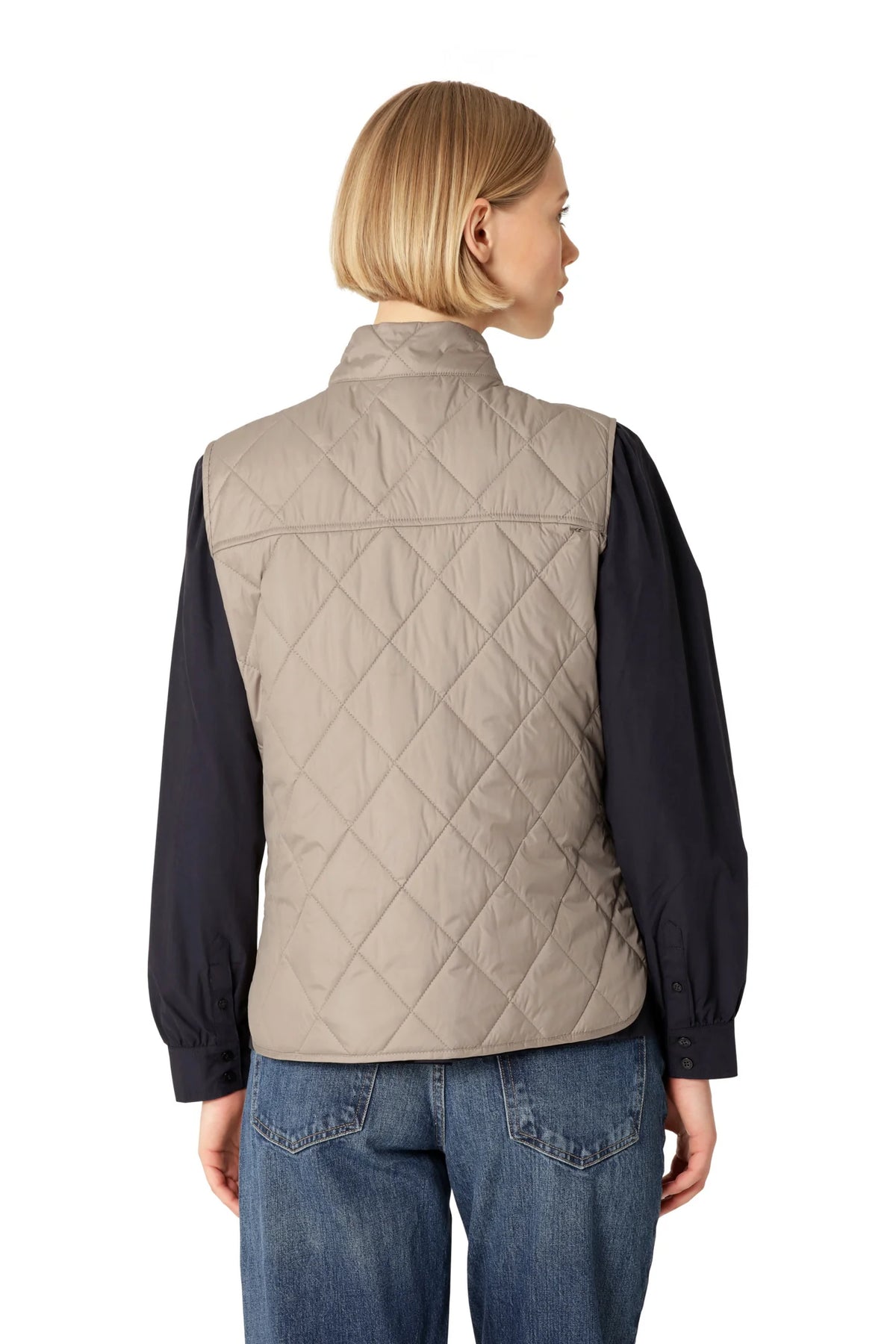 Ilse Jacobsen BEAT01 taupe quilted vest worn over navy long-sleeve shirt with jeans