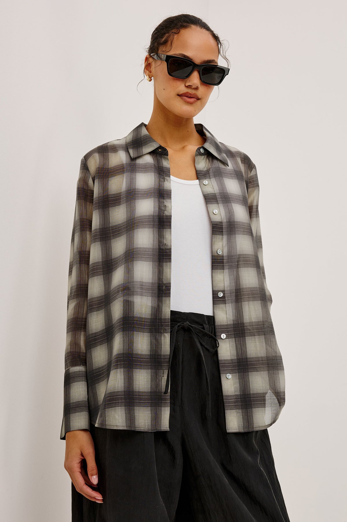 Model wearing Rails Bishop oversized plaid shirt in onyx-taupe with black trousers