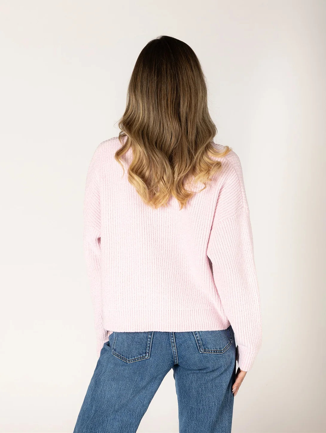 Back view of pink chenille ribbed sweater paired with blue jeans