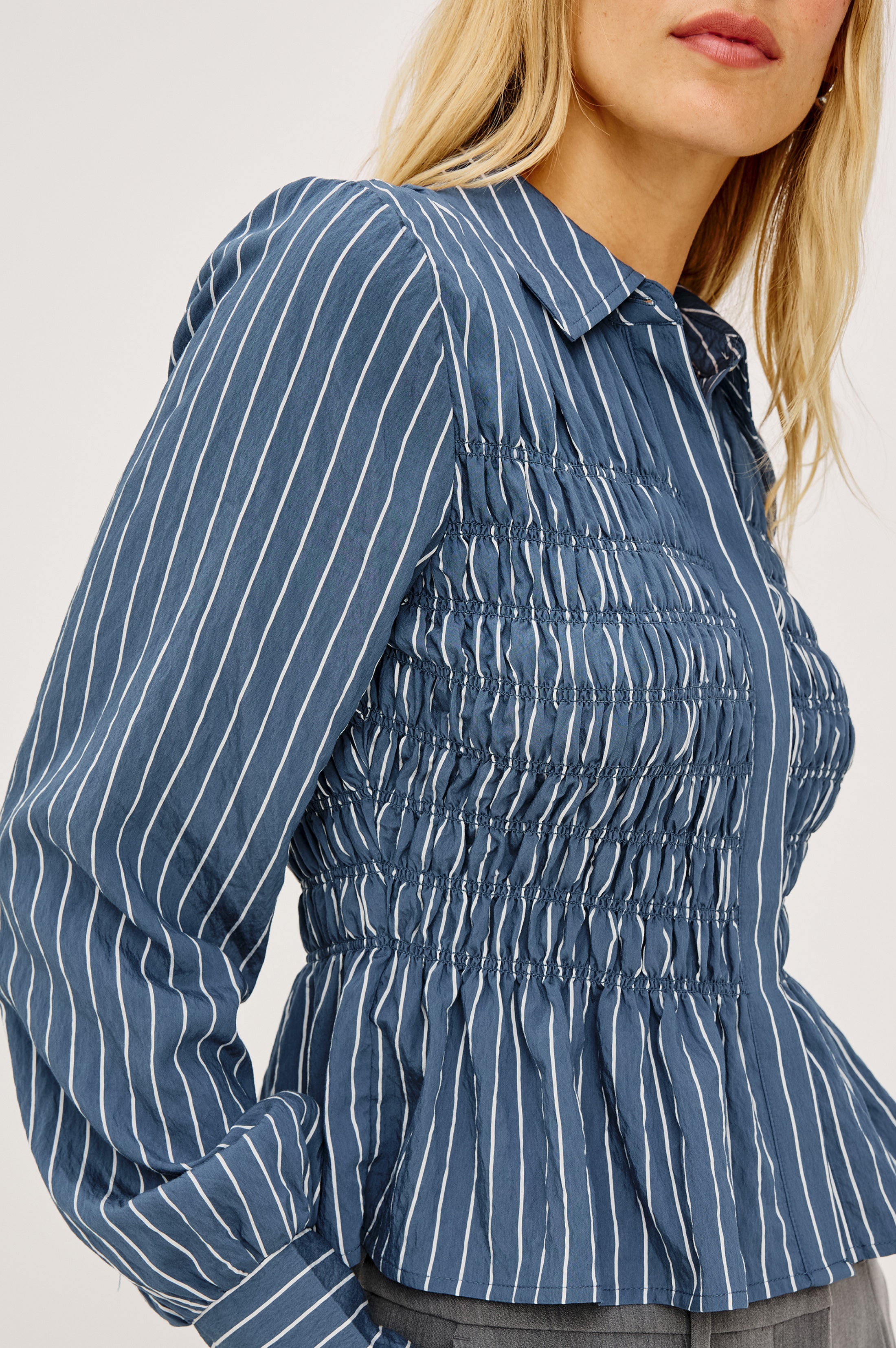 Close-up detail of Rails smocked blue striped long-sleeve shirt on blonde model
