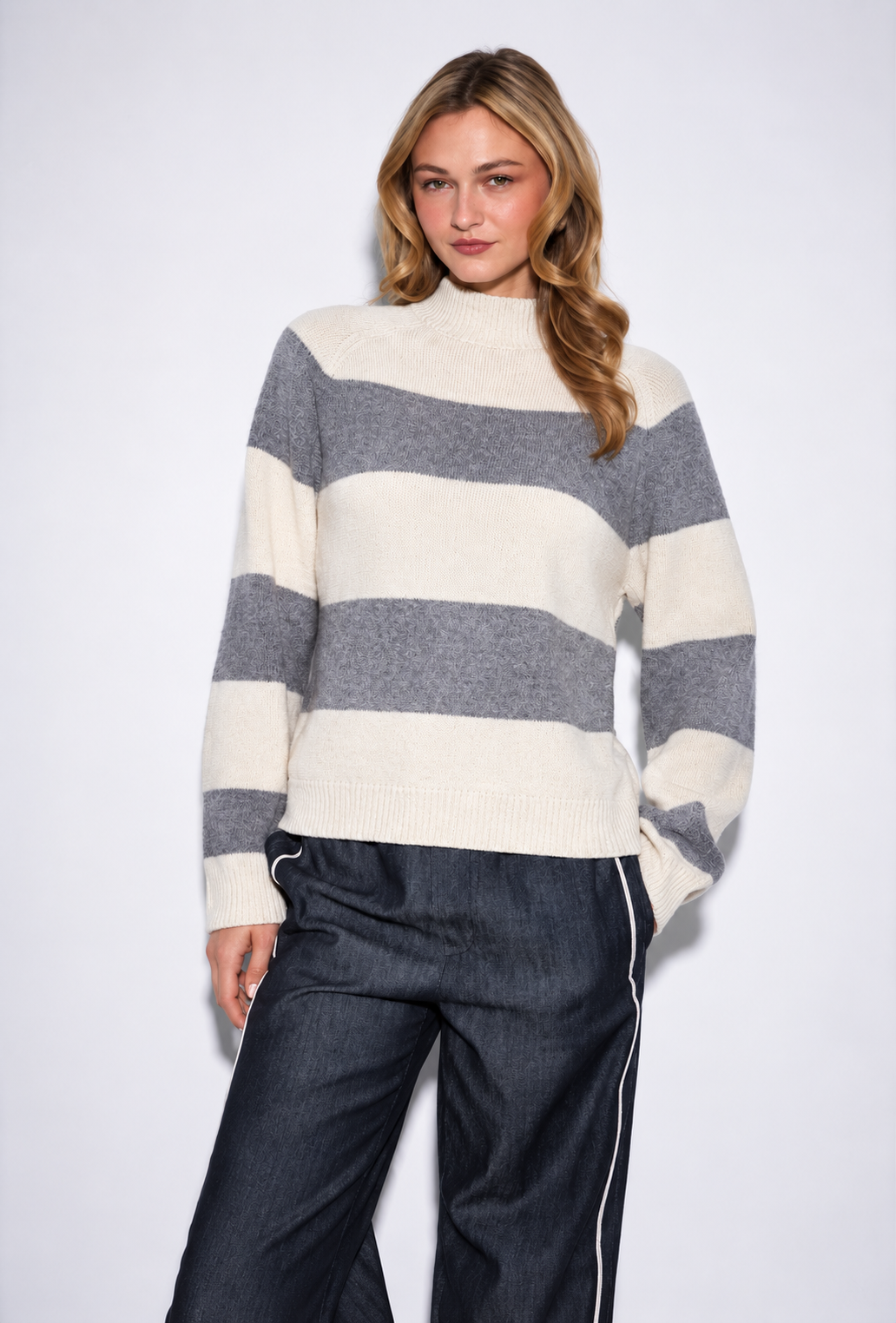 Woman wearing John & Jenn Edison pebbled stripe sweater in grey and cream on dark jeans