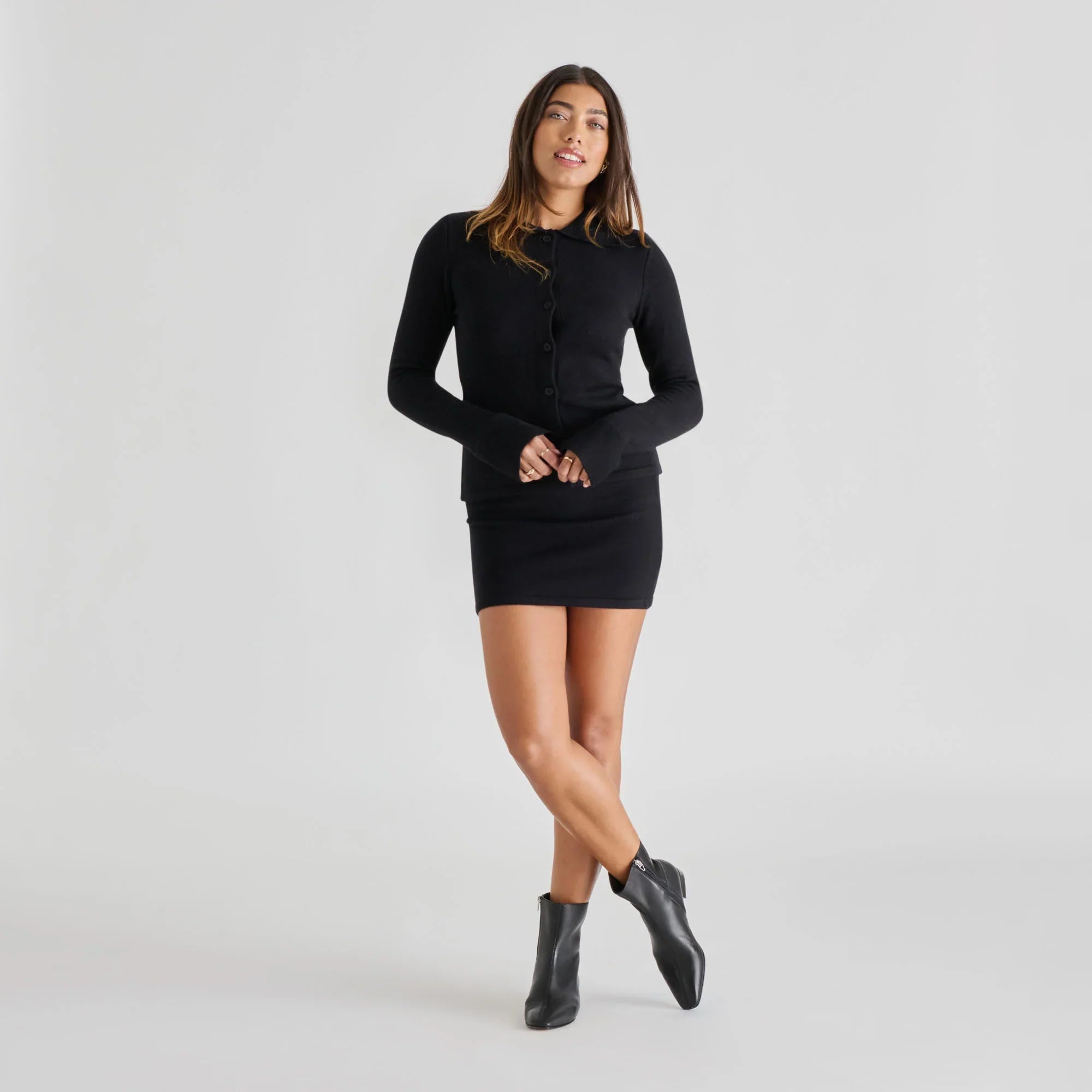 Black leather ankle boots with side zip, styled with black mini dress and cardigan