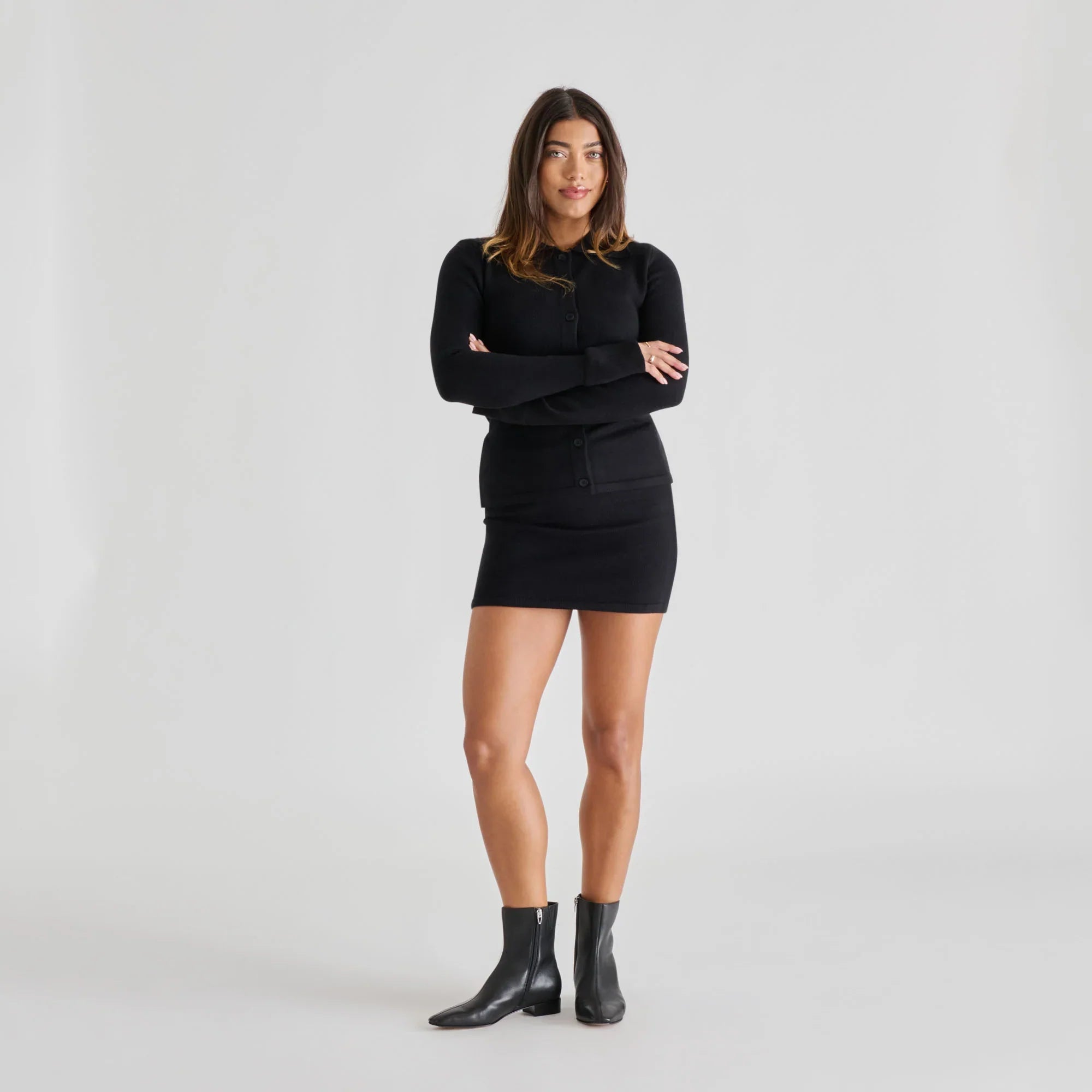 Black leather ankle boots with side zip closure, worn by a female model