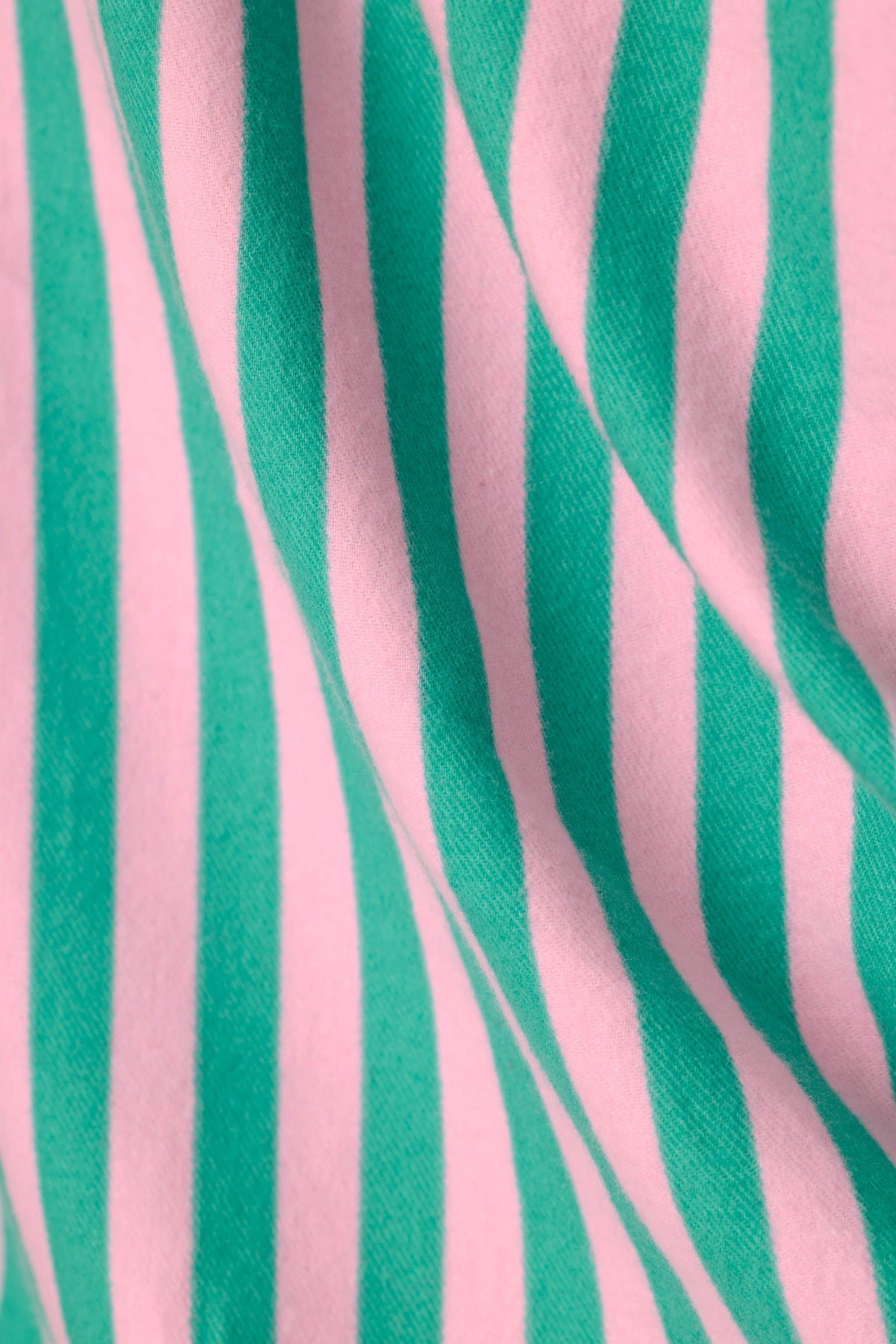 Close-up detail of pink and green striped soft flannel fabric with gentle draping folds