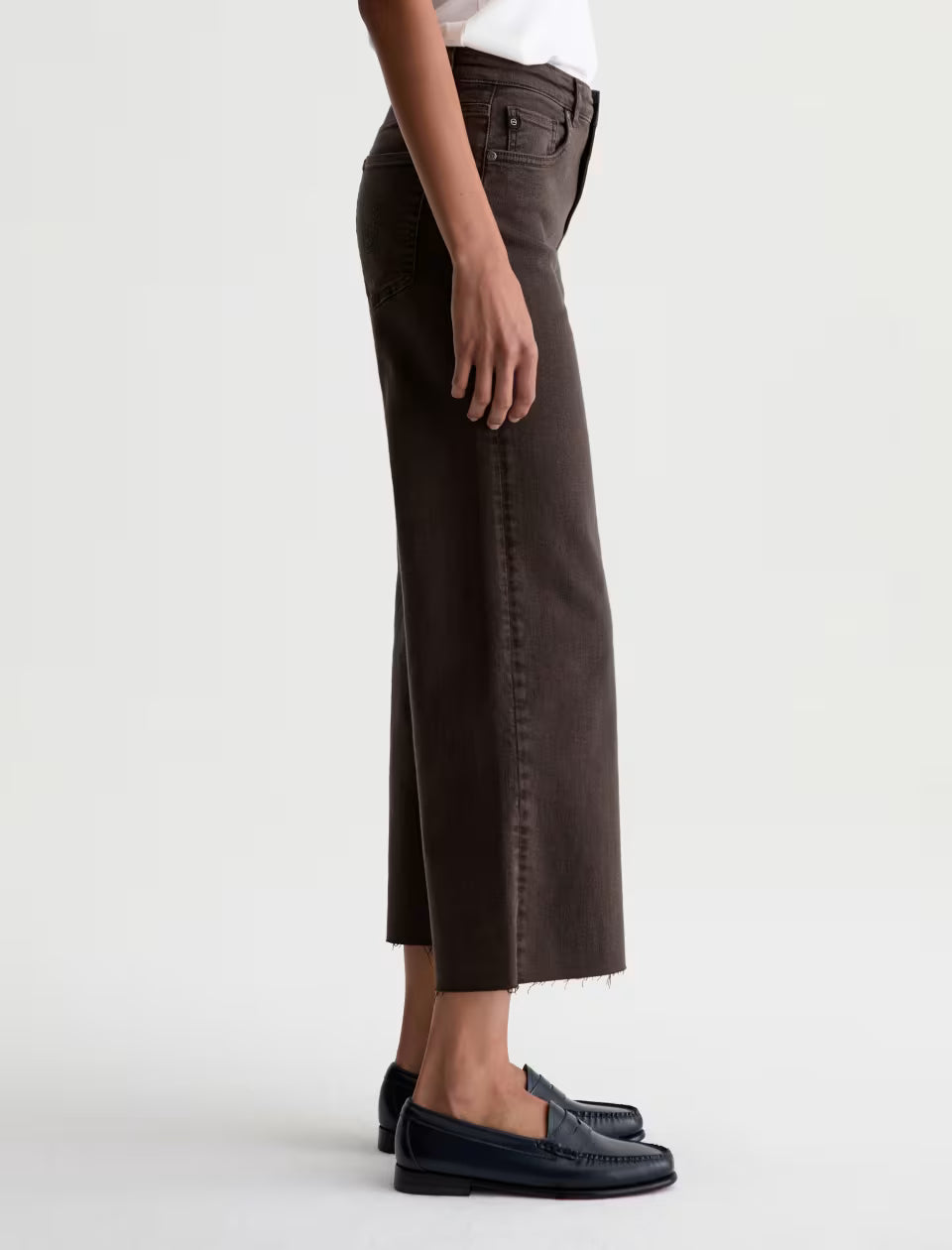 AG Saige wide leg crop jeans in dark brown with raw hem, side view