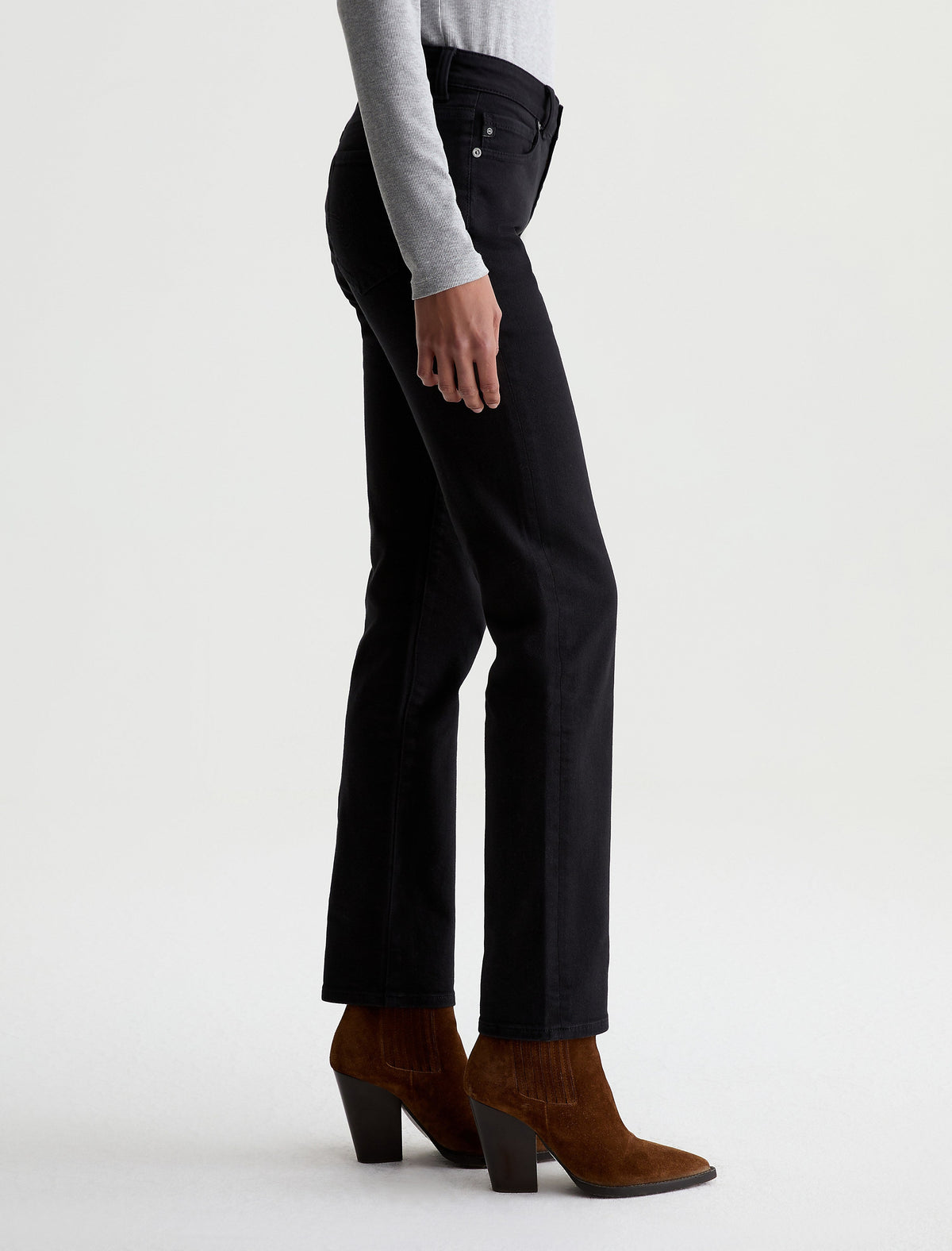 Side view of AG Sandra black straight-leg jeans worn with brown suede western boots