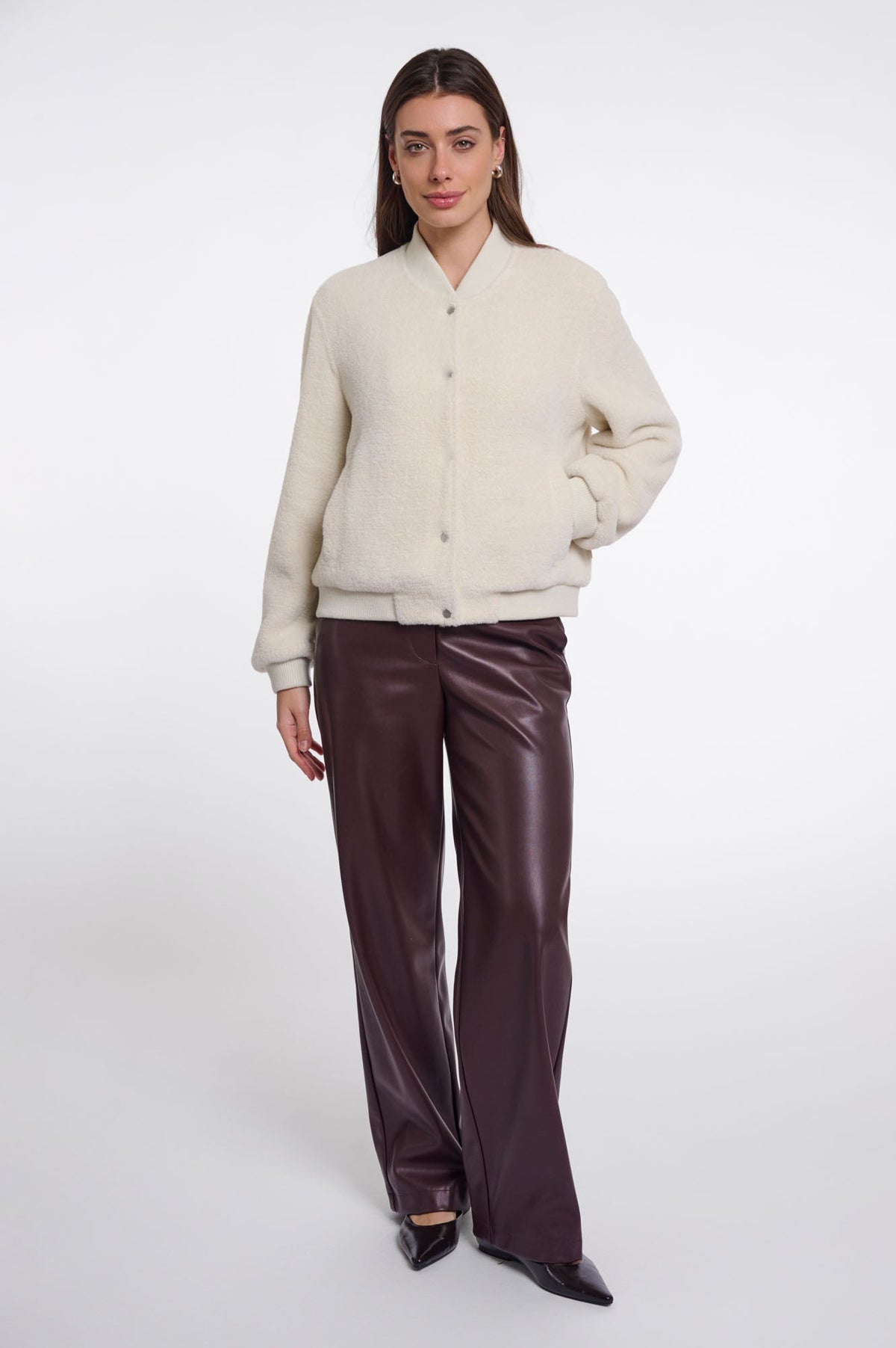 Model wearing Rino & Pelle Felix cream bouclé bomber jacket with burgundy leather trousers