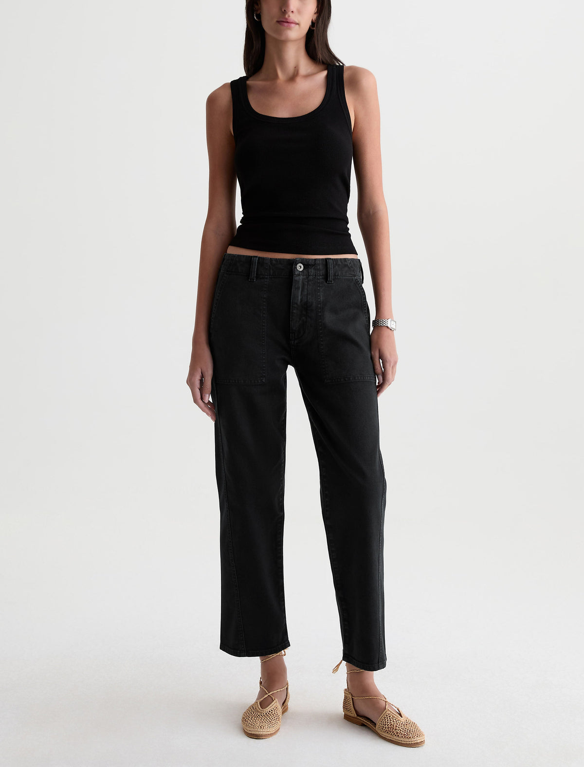 Model wearing AG Analeigh Sulfur Super Black wide-leg cropped pants with black tank top