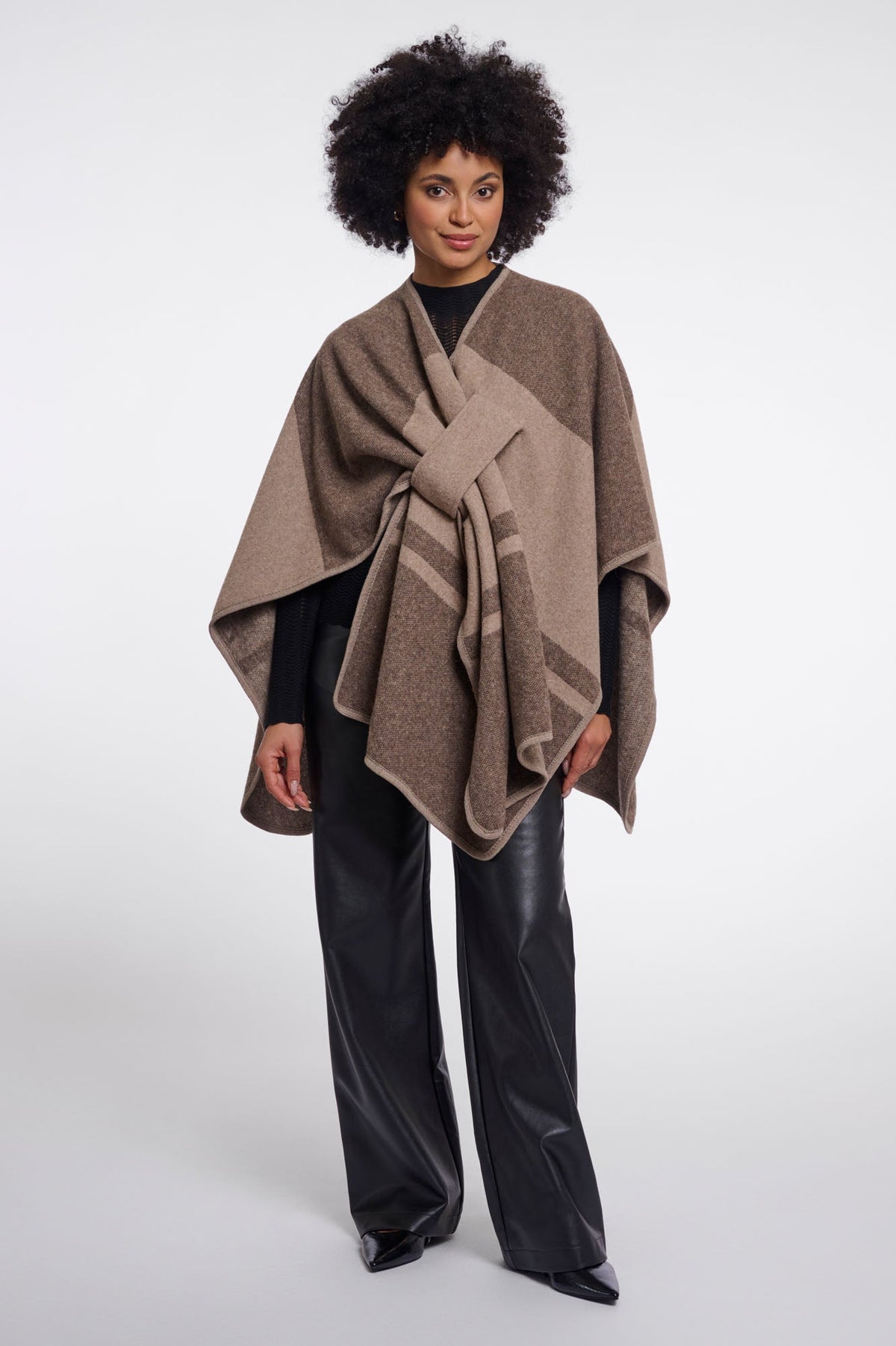 Model wearing Rino & Pelle Levi wrap poncho in toffee check with black trousers