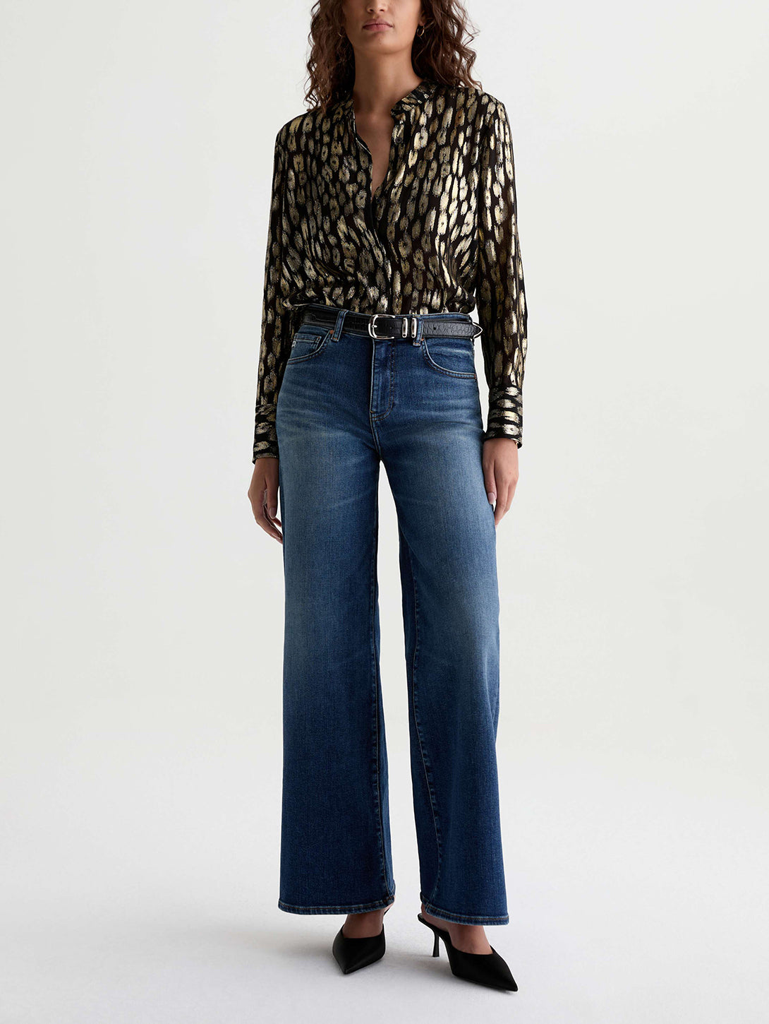 Model wearing AG Saige Wide Leg jeans in 14 Years Bluegrass medium blue wash with black belt