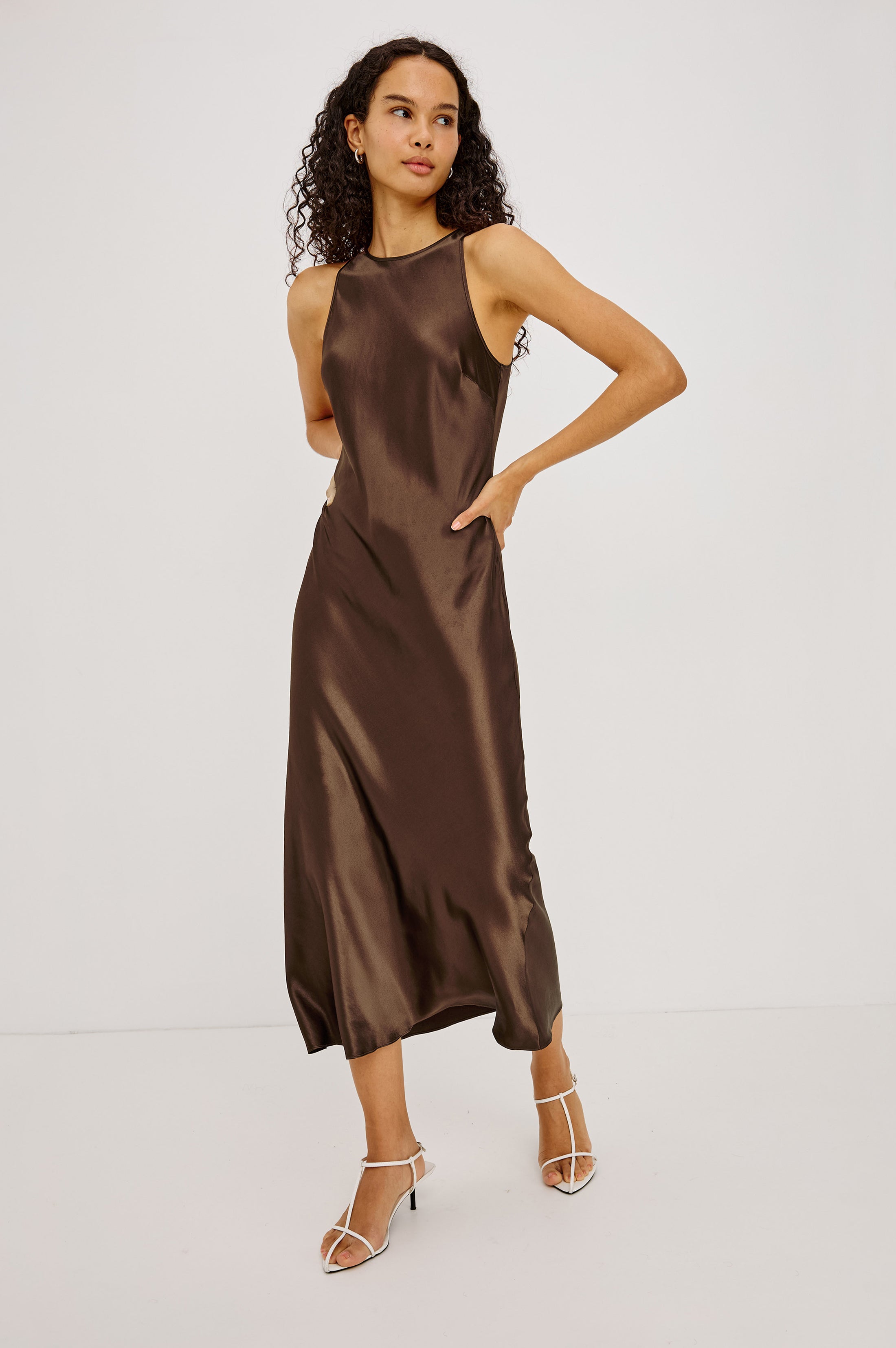 Model wearing Rails Solene Espresso satin midi dress with halter neckline and white heels
