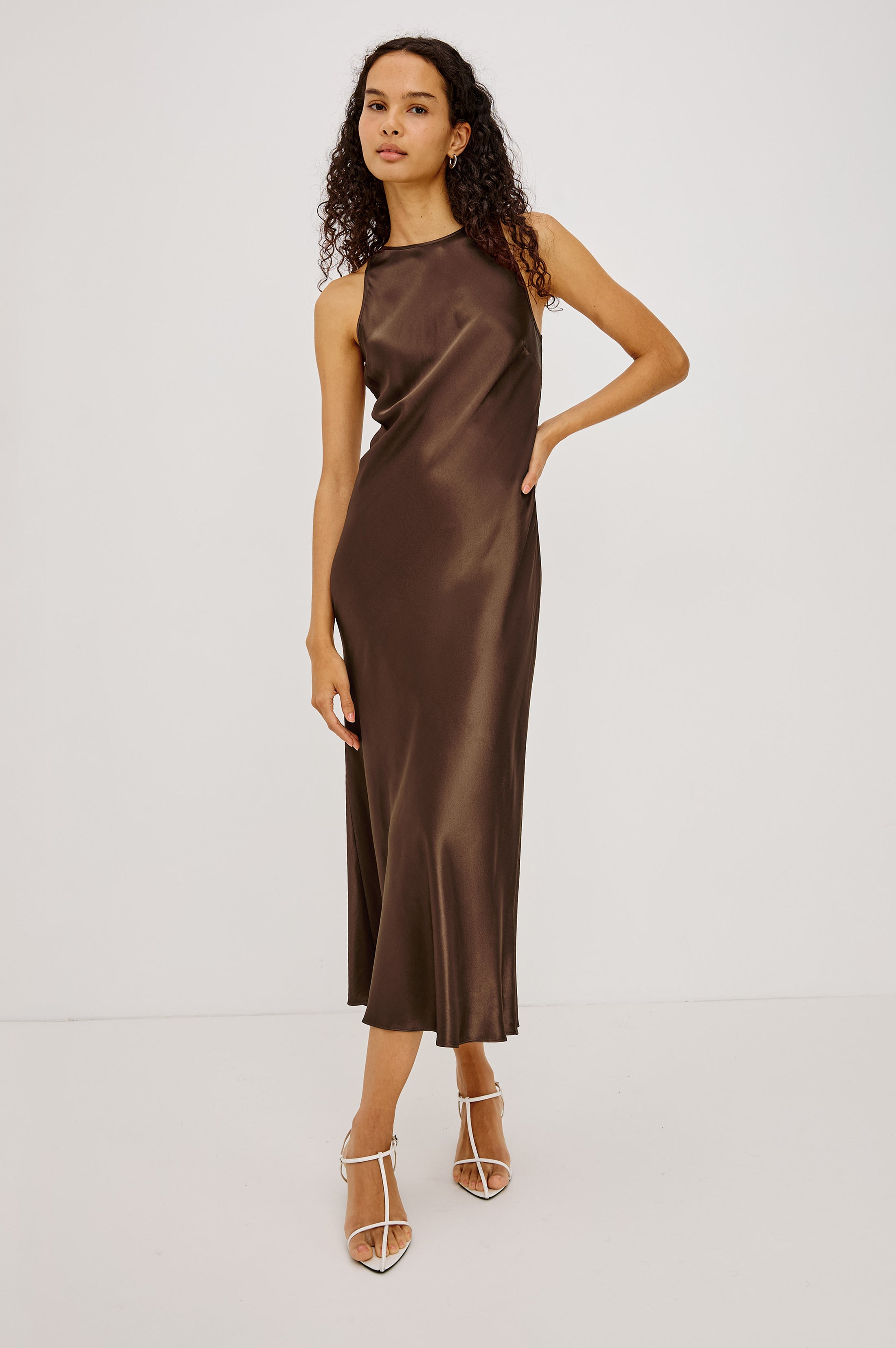 Model wearing Rails Solene Espresso satin midi slip dress in deep brown with halter neckline.