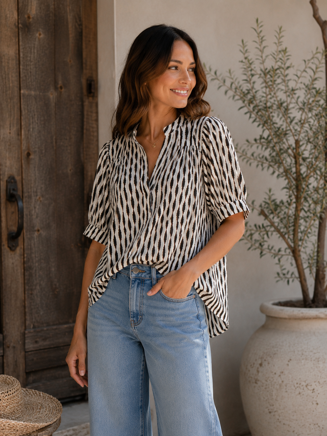 Woman wearing Sanctuary Eden Button Blouse in Ink Blot print with light blue jeans