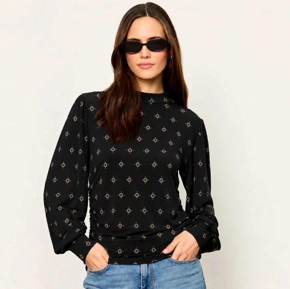 Black long-sleeve mock neck top with gold geometric charm print and cinched cuffs