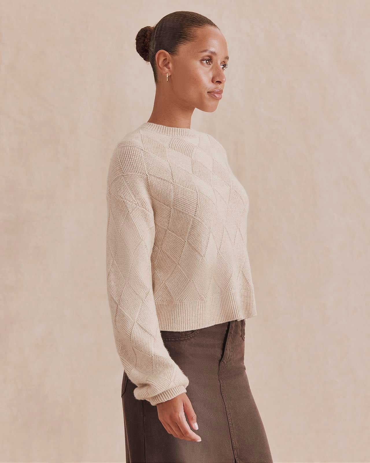Model wearing Splendid Solstice cream knit sweater with diamond texture pattern, side view