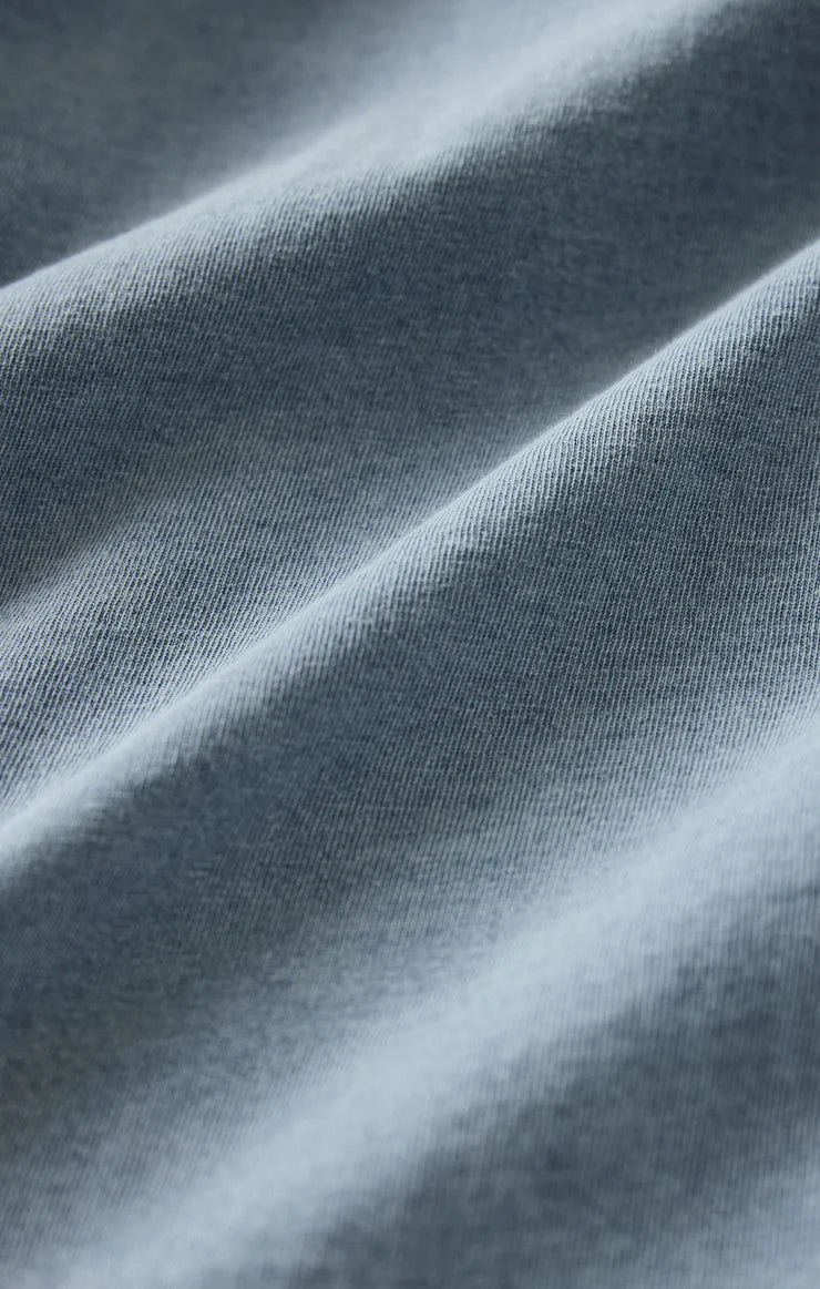 Close-up of soft blue-gray jersey knit fabric with gentle folds and texture