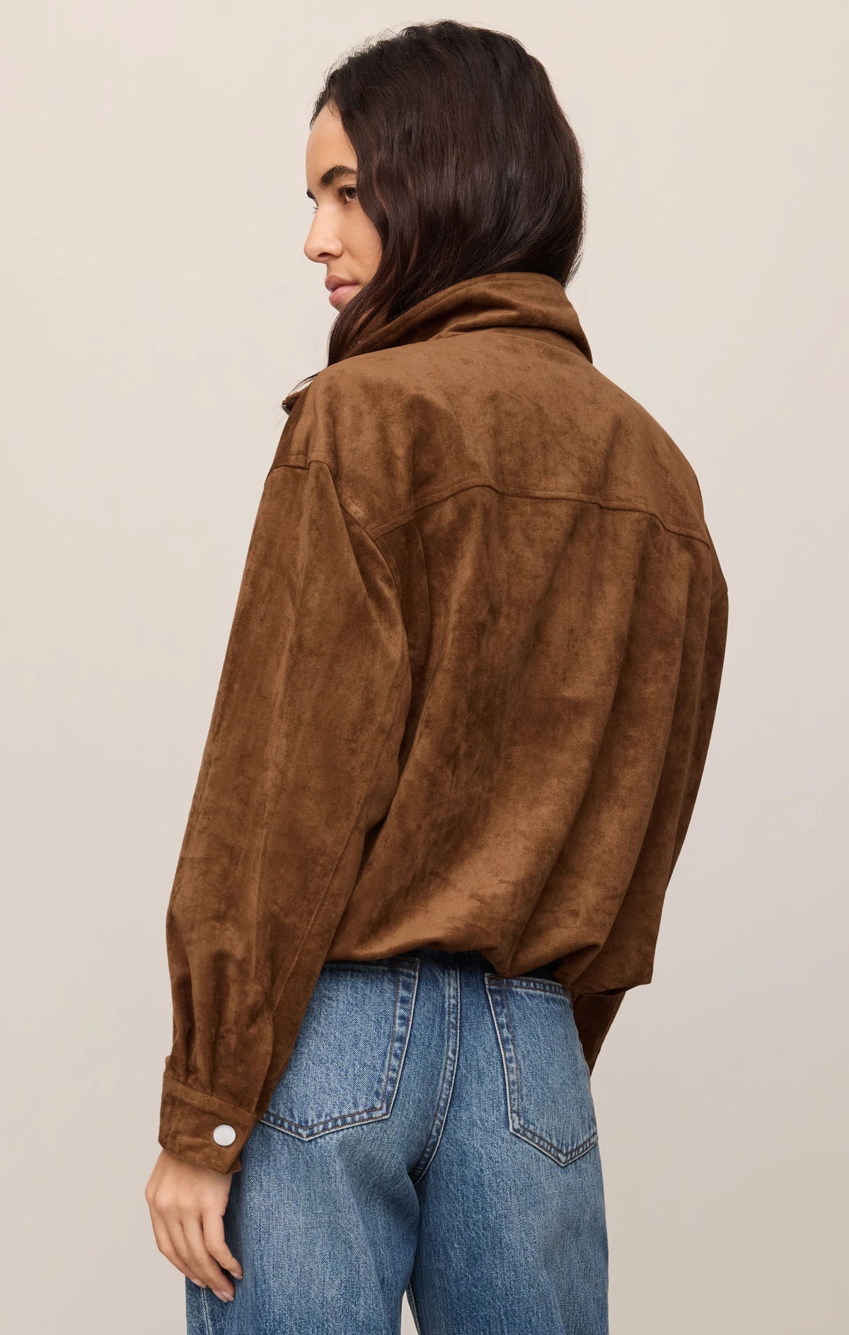 Brown suede bubble hem jacket with snap cuffs, back view, paired with jeans