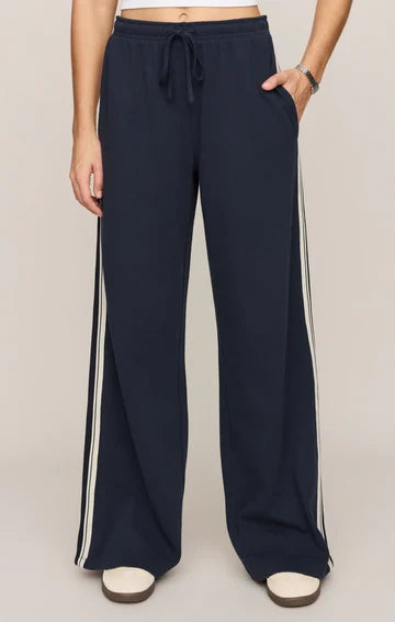 Navy wide-leg track pants with white side stripes and drawstring waist