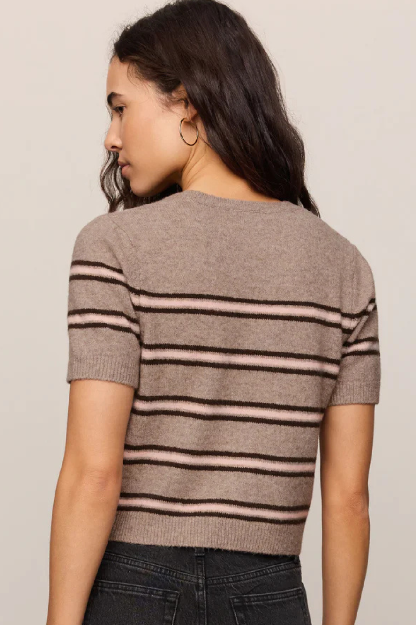 Back view of woman wearing Z Supply Gatewood stripe sweater in heather ash with pink stripes