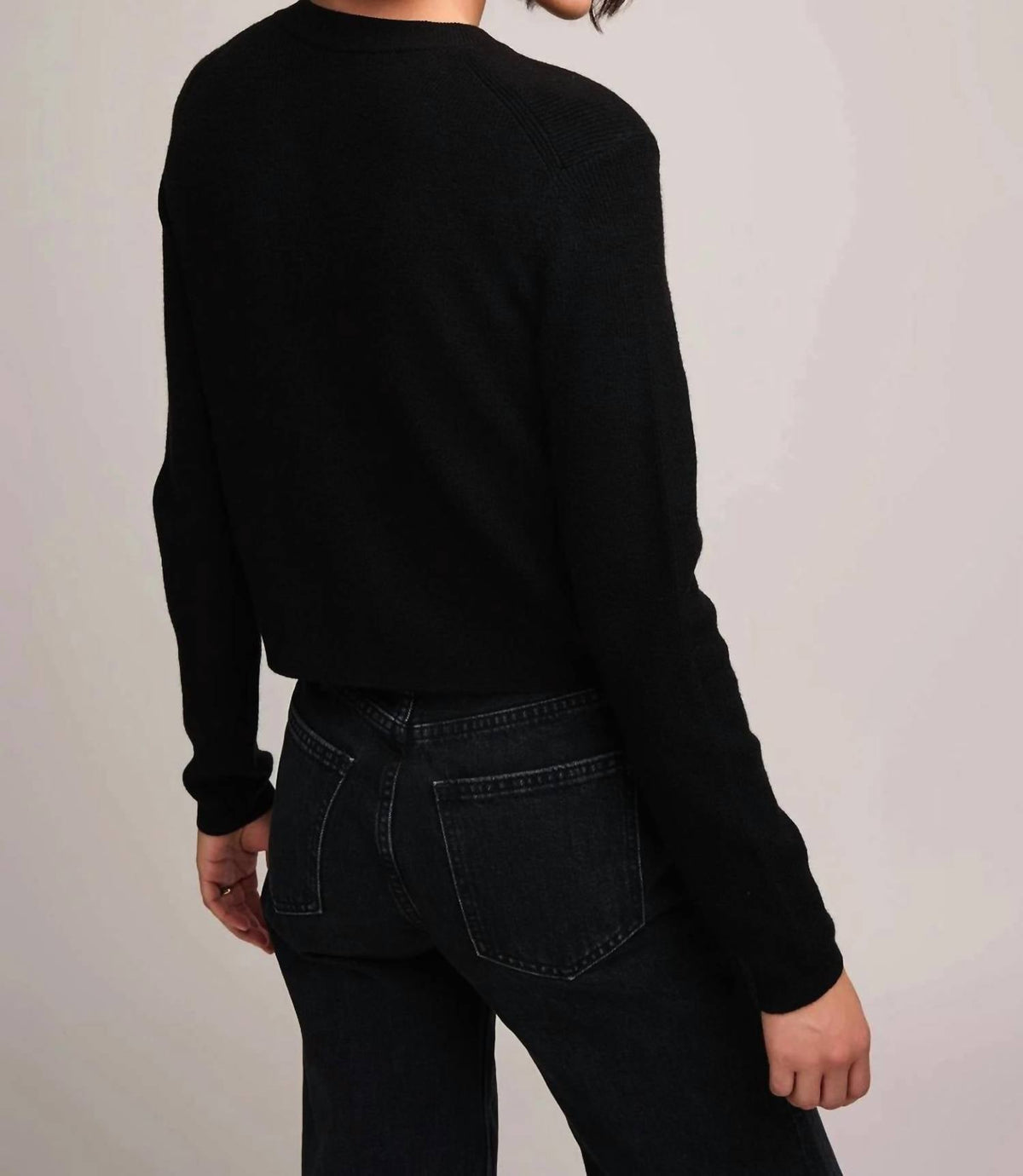 Back view of Gentle Fawn Mirabelle black knit sweater paired with dark jeans on model