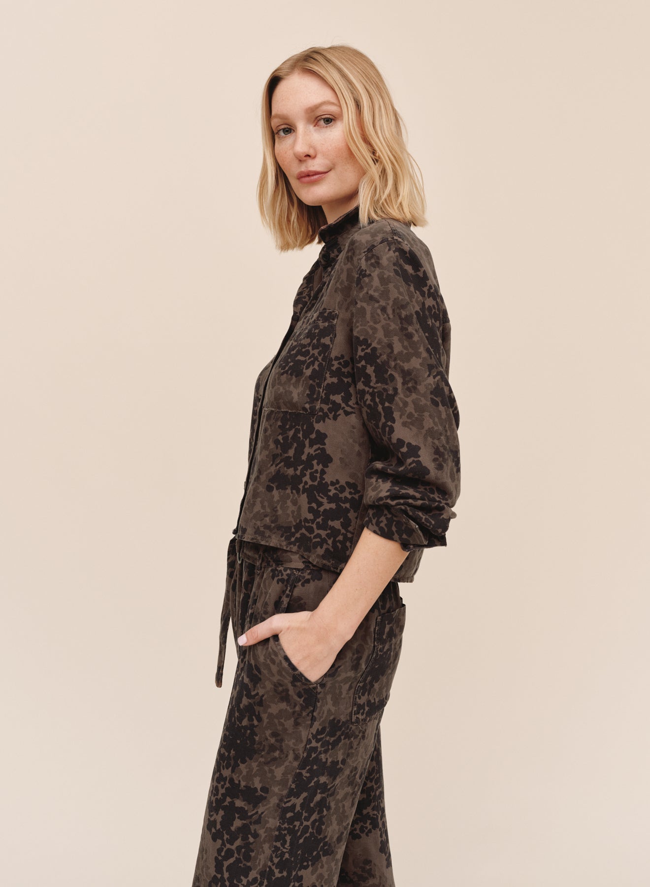 Model wearing Bella Dahl long sleeve crop pocket shirt in ditsy camo print, side view