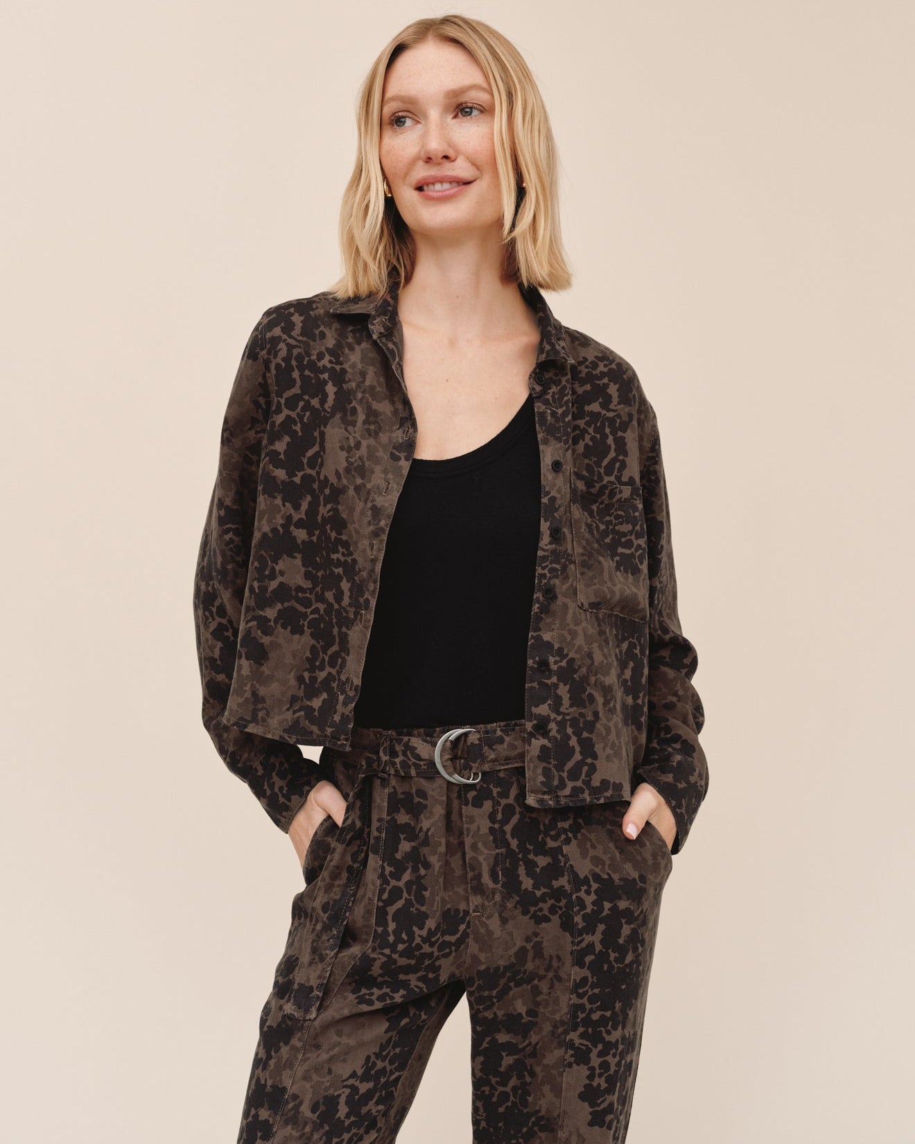 Model wearing Bella Dahl long sleeve crop pocket shirt in brown ditsy camo print with matching pants
