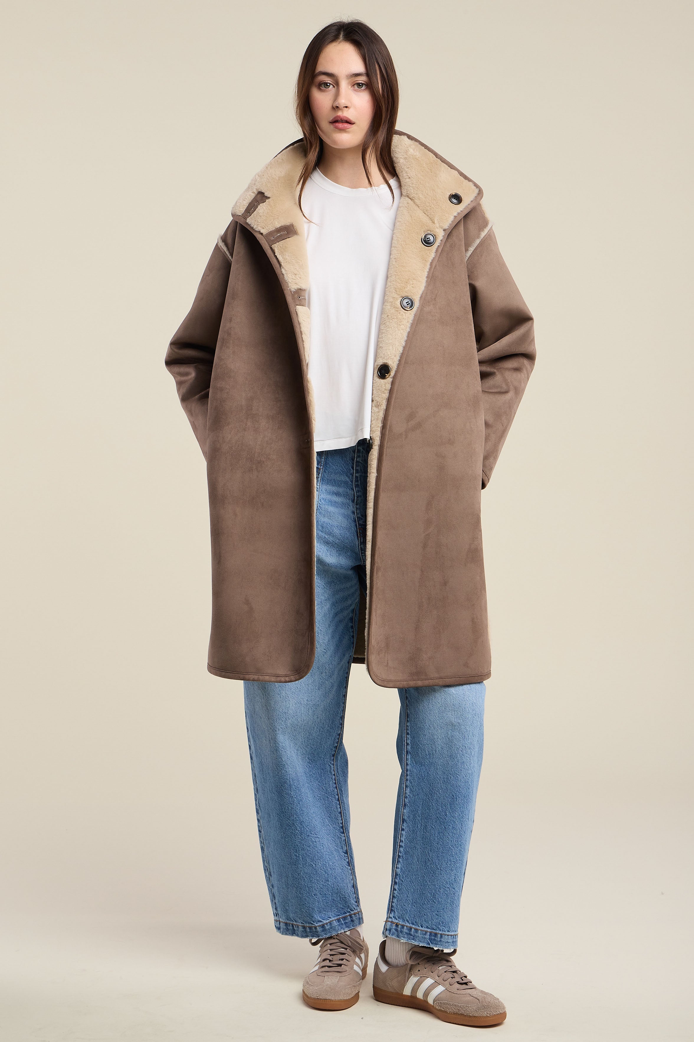 Model wearing Velvet YVES07 oversized faux shearling coat in faded coco with cream lining and jeans