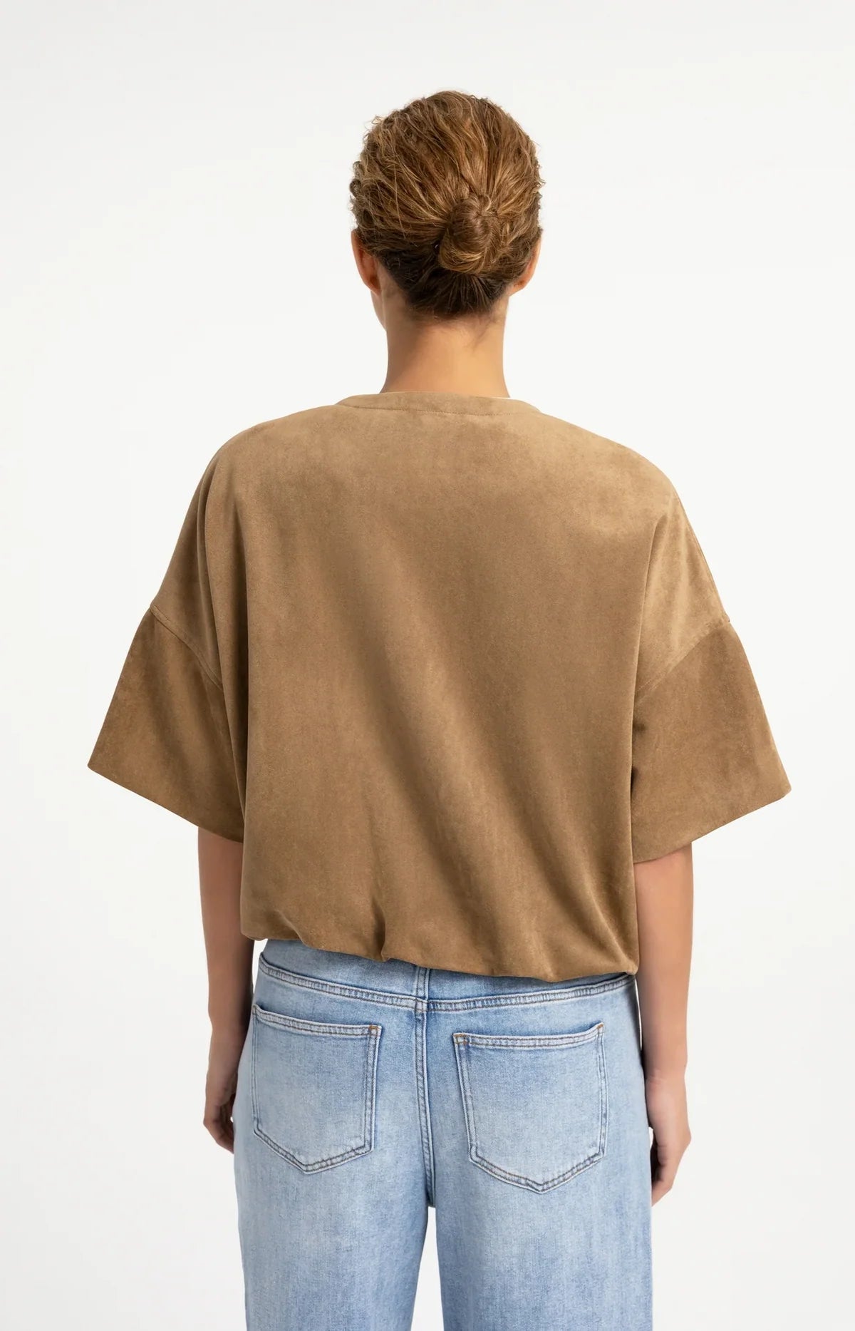 Oversized tan suedine top with balloon hem, back view, paired with light blue jeans
