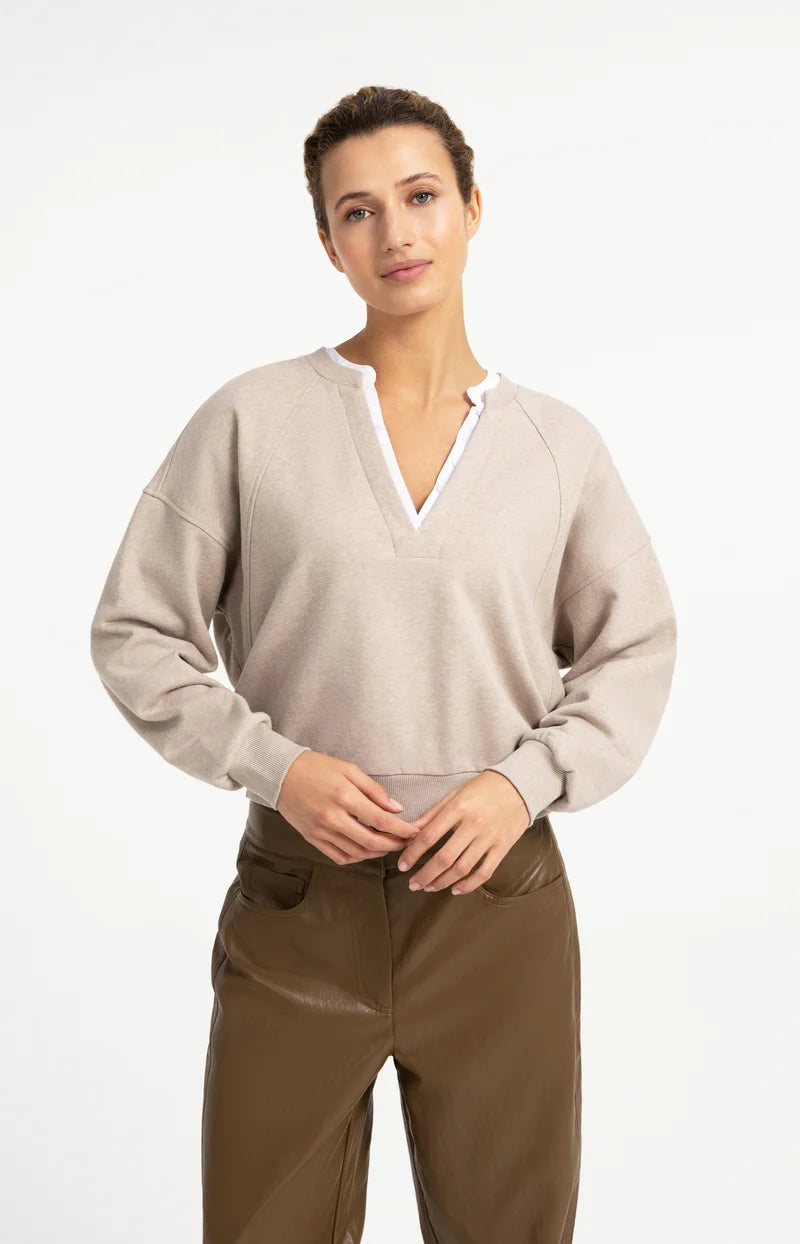 Beige oversized V-neck sweatshirt with white woven collar detail, raglan sleeves