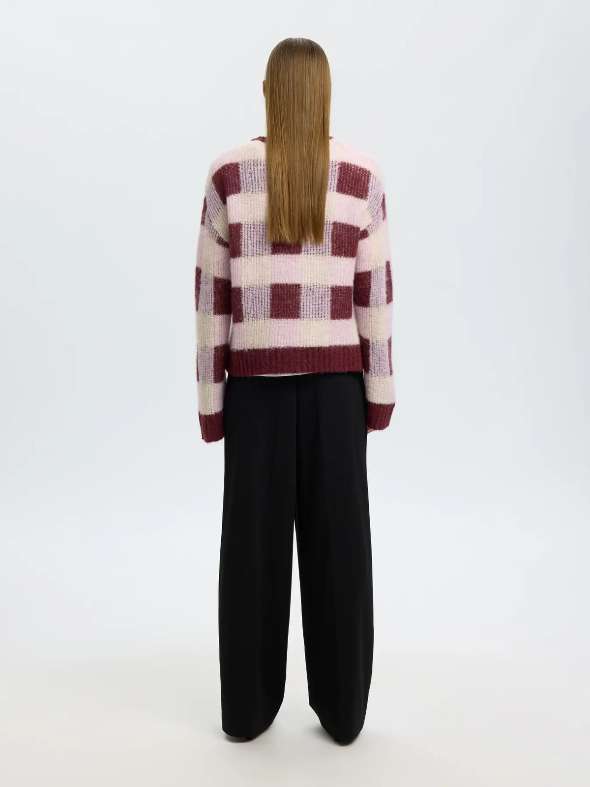 Back view of model wearing SELECTED SLWLULU loose check knit O-neck sweater in burgundy and pink
