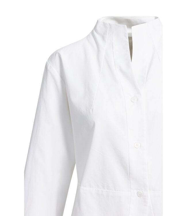 Close-up detail of white A-line blouse showing high neck and button placket