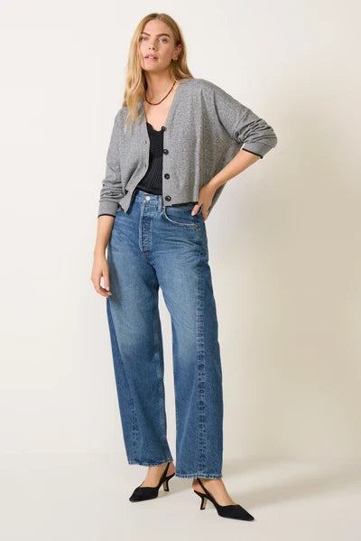 Grey cropped V-neck cardigan with black buttons, worn open over black top