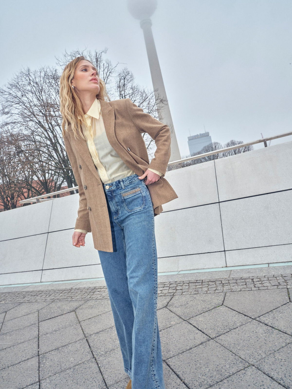 Model wearing Mos Mosh Bethie Case Blazer in dark camel with wide-leg jeans outdoors