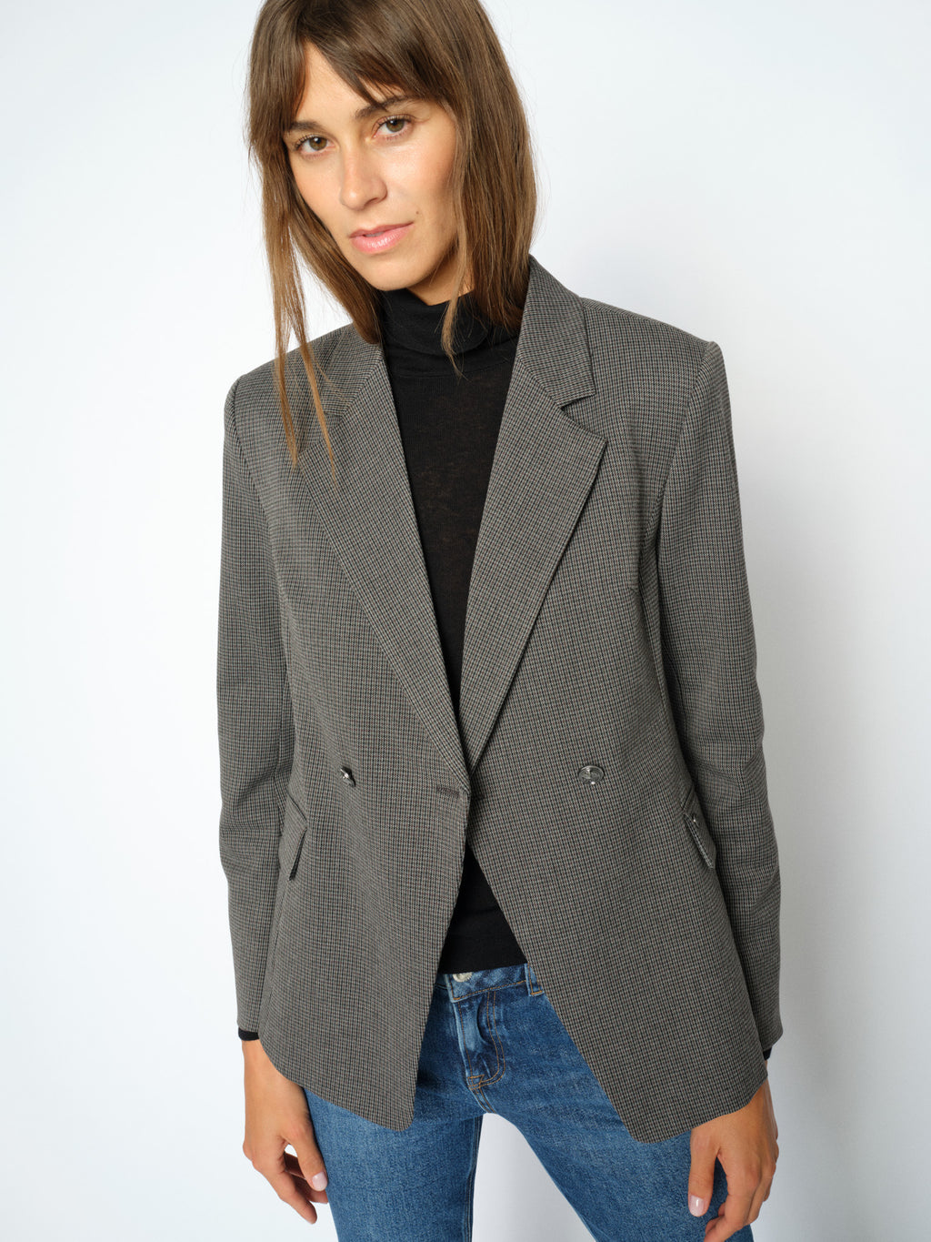 Grey houndstooth blazer with notch lapels and silver buttons, worn open