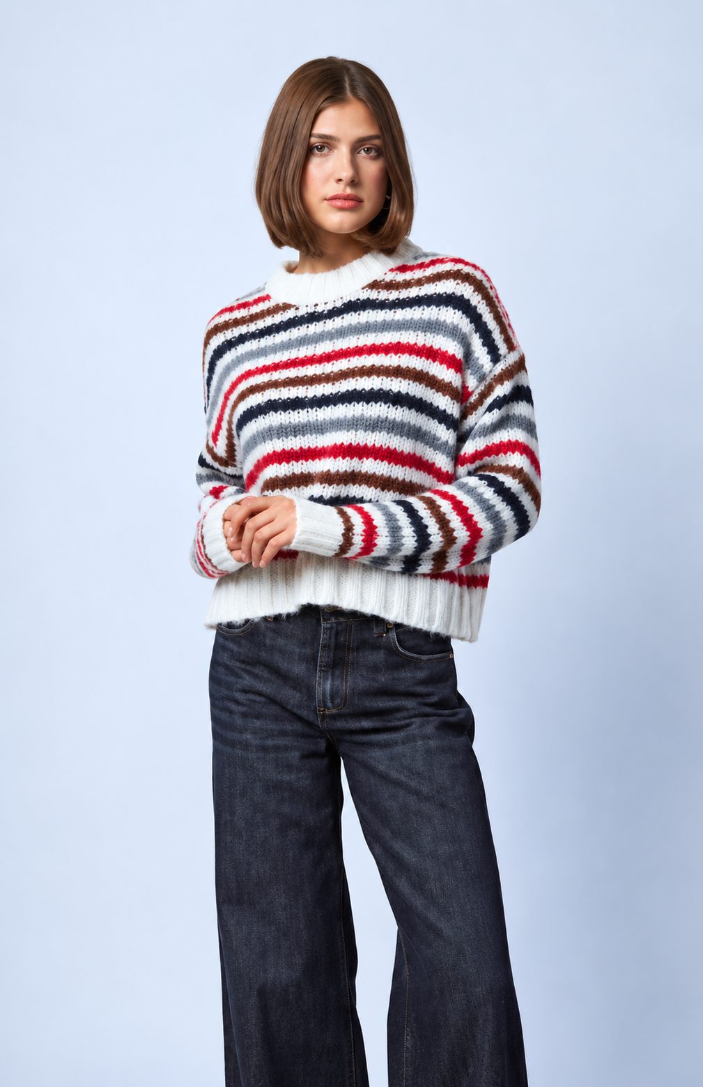 Model wearing Line the Label Theodora striped knit sweater in Tundra Stripe with wide-leg dark jeans