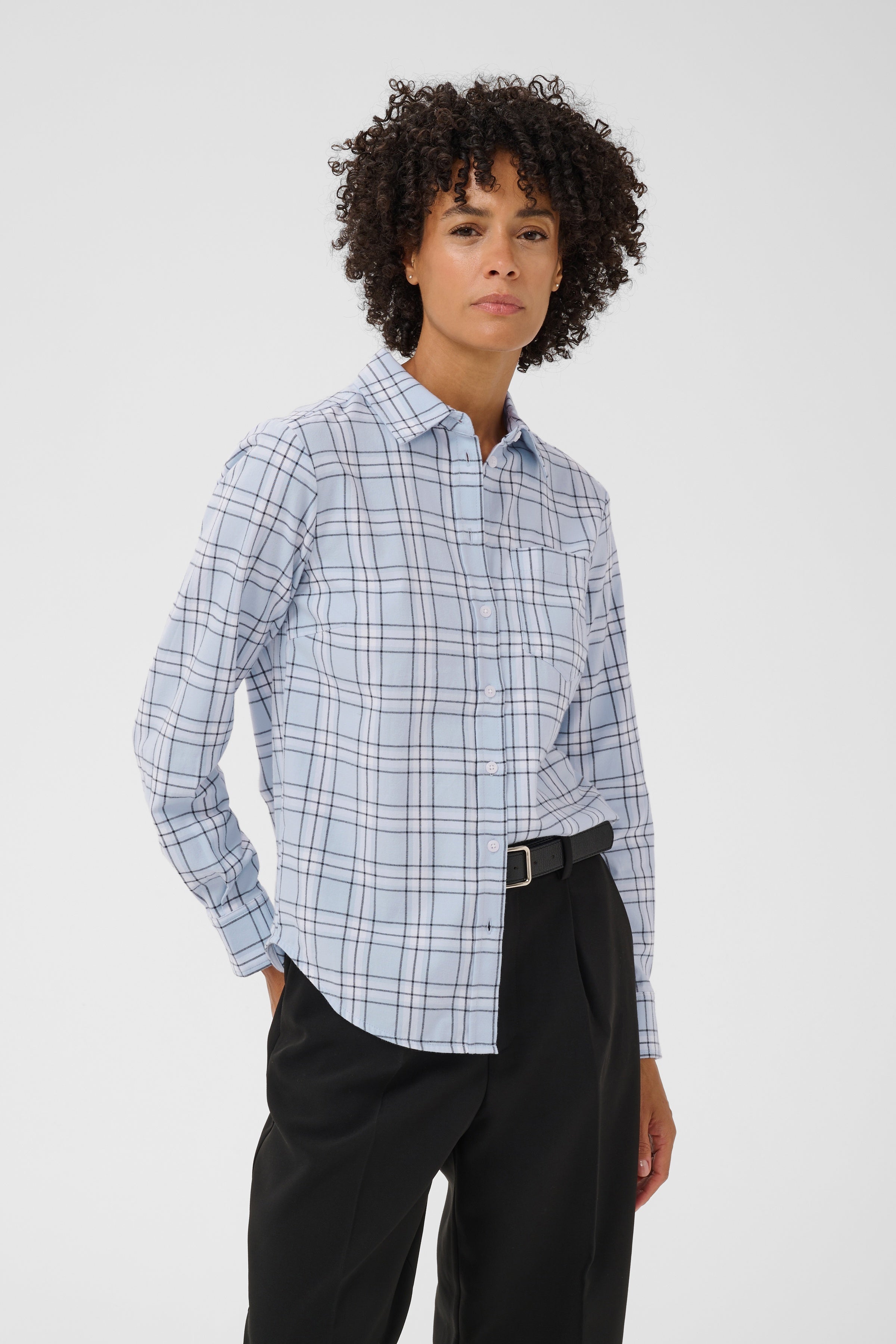 Model wearing Part Two Yana Shirt in heather check light blue plaid with black trousers
